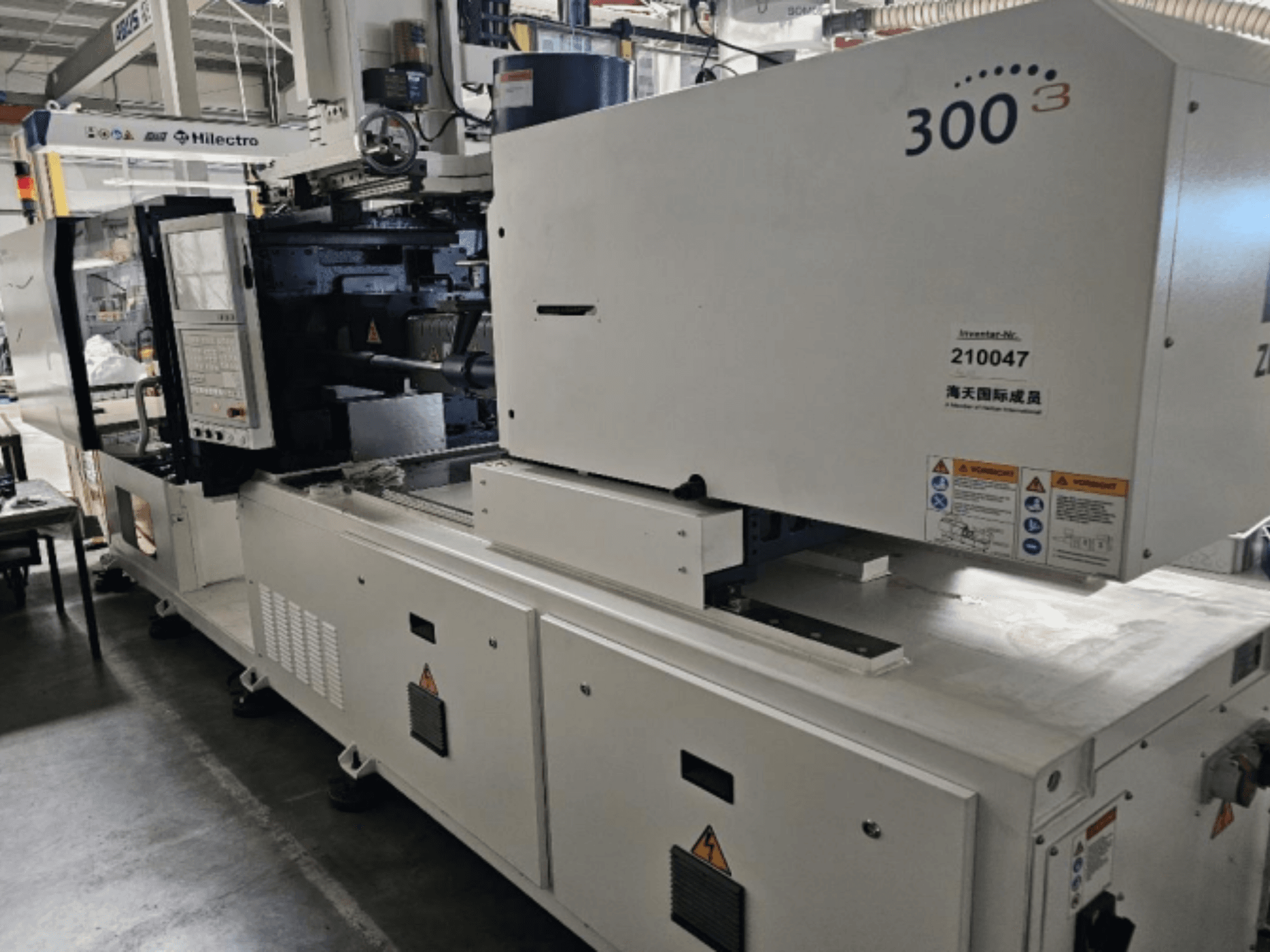 Machine de moulage par injection, marque Zhenjing, modèle 300, vue de face avec panneau de commande et étiquettes d'avertissement de sécurité visibles.