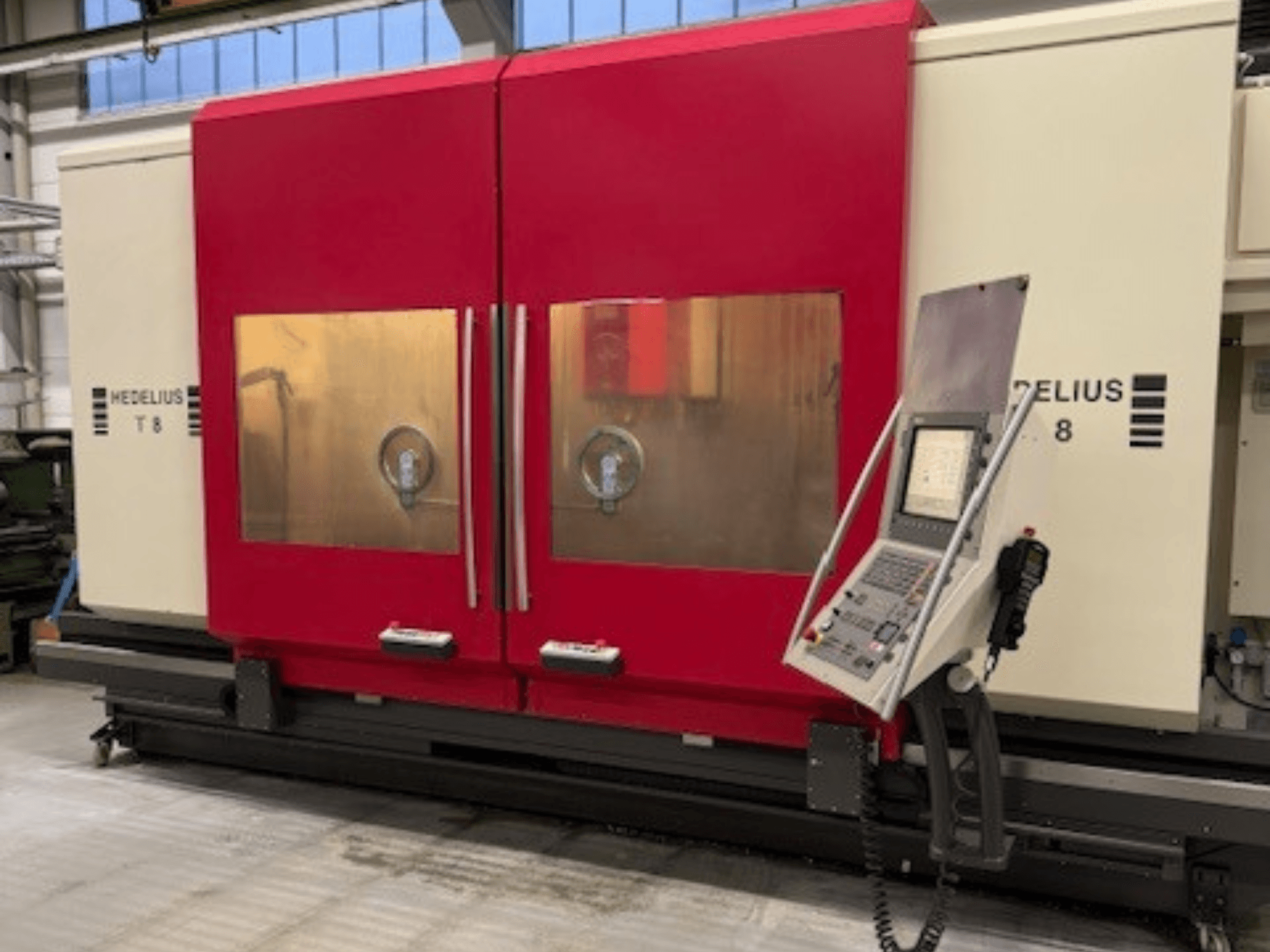 Machine CNC HEDELIUS T8 vue de face, avec les portes rouges, le panneau de commande et la visibilité des composants internes.