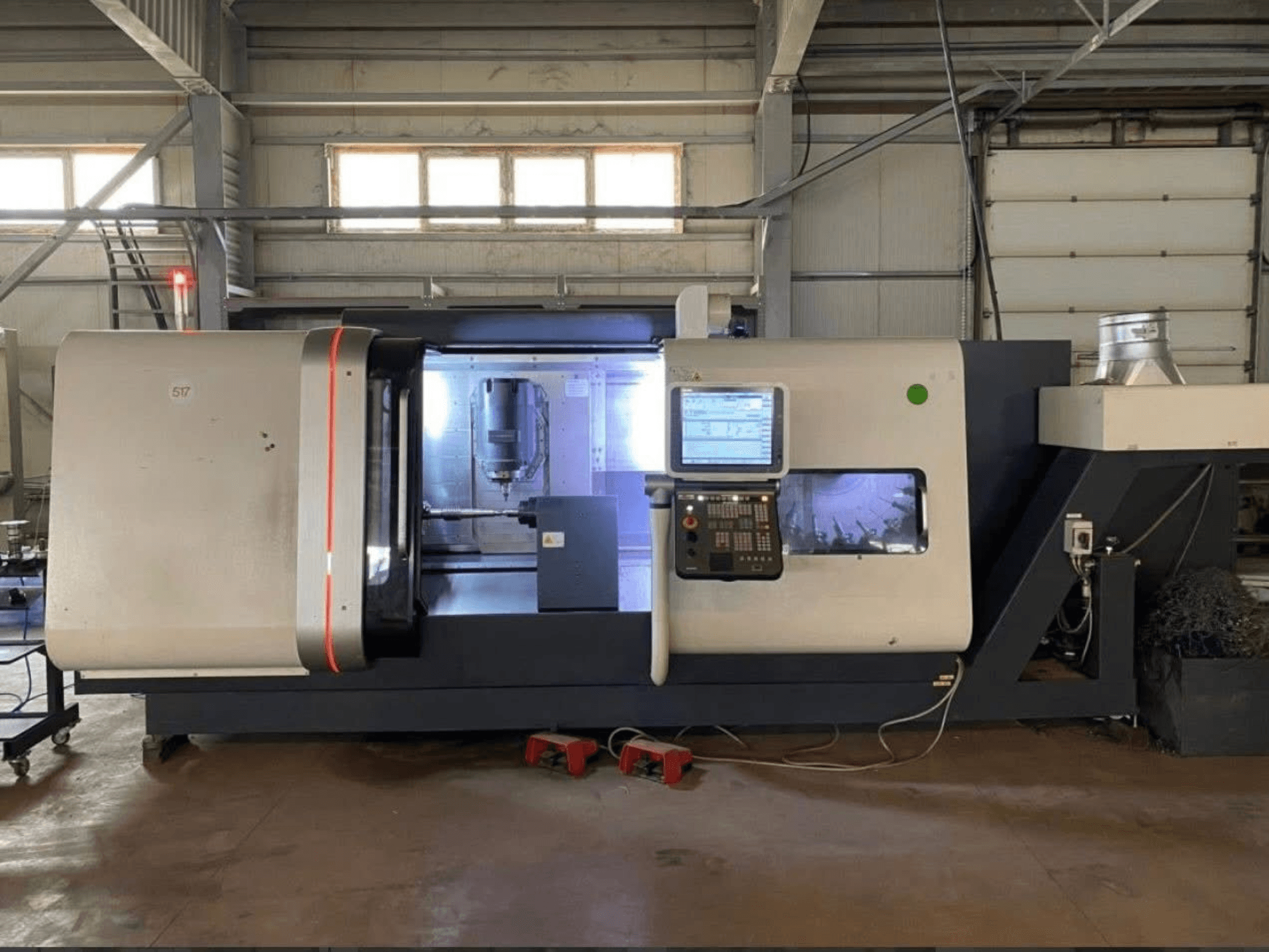 Centre de tournage-fraisage DMG MORI Beta 1250 TC, vue de face avec panneau de commande, espace de travail éclairé et outils de coupe visibles.