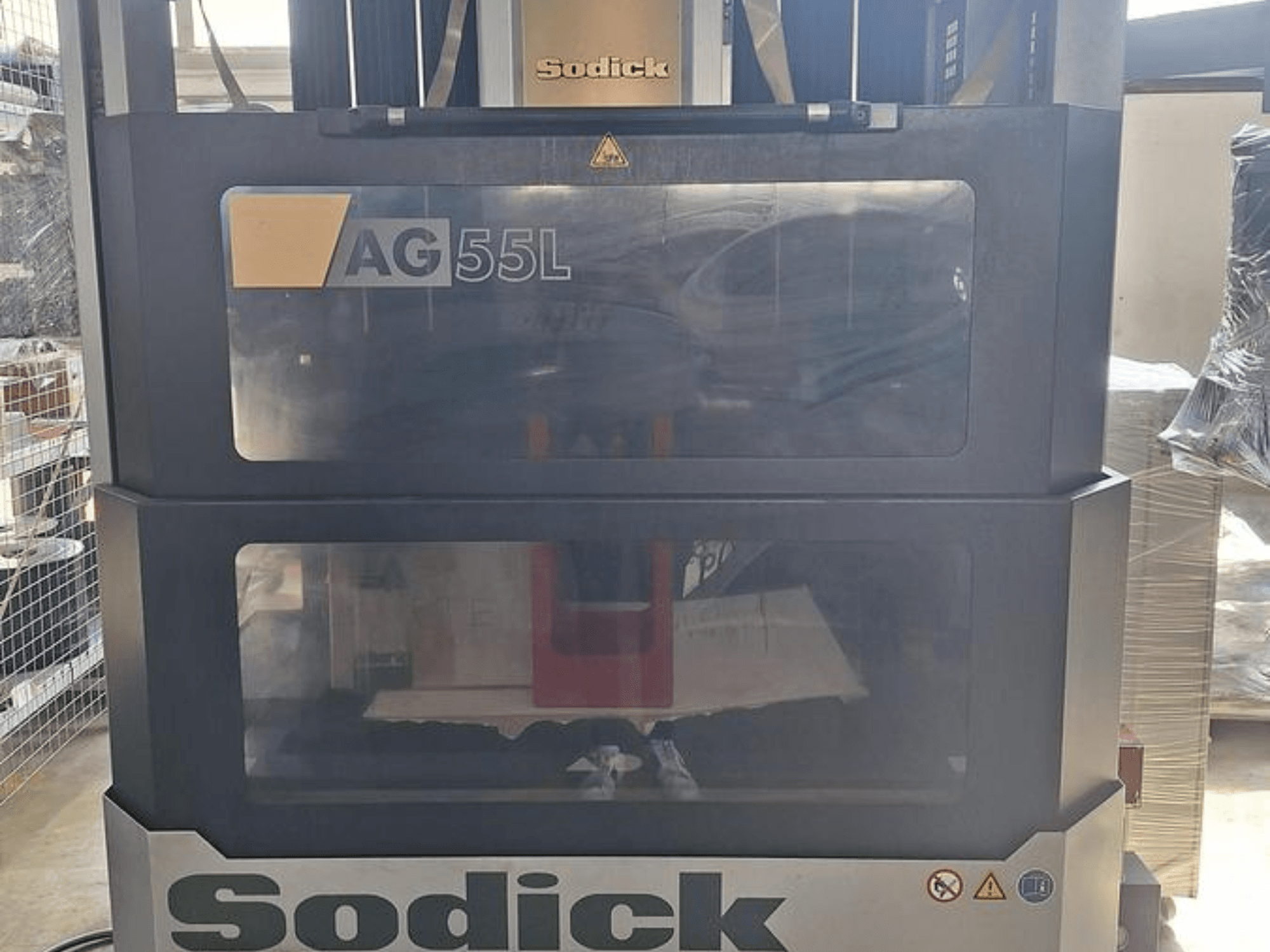 Machine d'électroérosion par enfonçage Sodick AG 55L, vue de face avec les commandes visibles à travers des panneaux transparents, montrant l'espace de travail à l'intérieur.