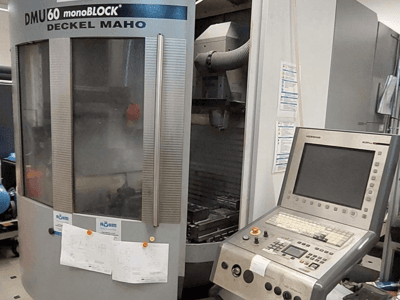 DMU 60 monoBLOCK de Deckel Maho, vue de face d'une fraiseuse CNC avec un panneau de commande et des dessins techniques attachés.