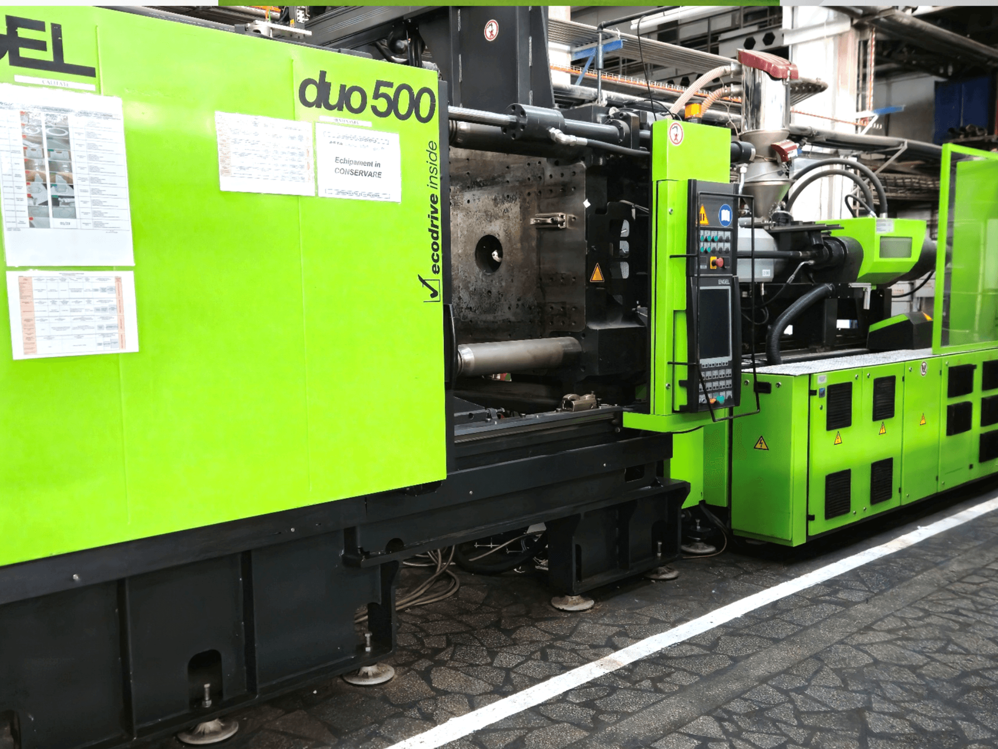 Machine industrielle verte Ergotron duo 500, vue de face ; comprenant le panneau de commande, les détails techniques et les étiquettes de sécurité de l'équipement.