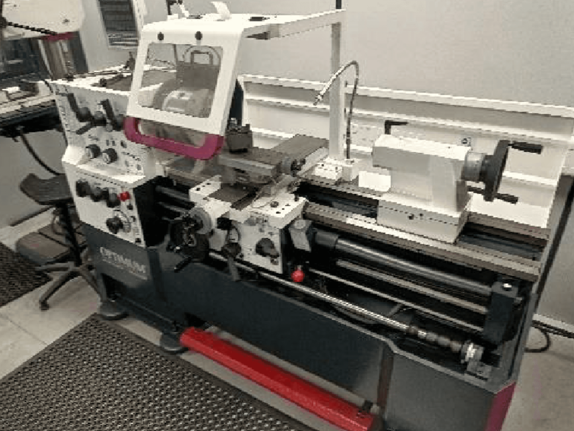 Vue de face de la machine-outil Optimum TH 4610, mettant en évidence les commandes, la broche et la zone de travail avec des détails bien visibles.