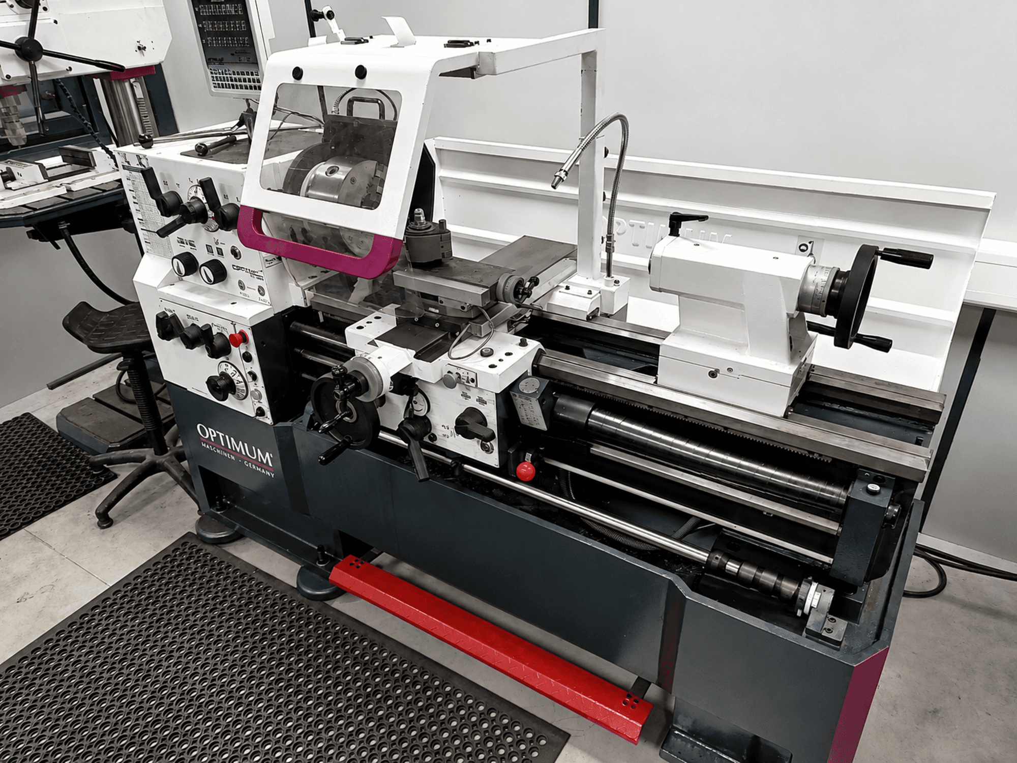Tour horizontal Optimum TH 4610, vue de profil, présentant les commandes, le mandrin et l'espace de travail, le tout dans une conception robuste.