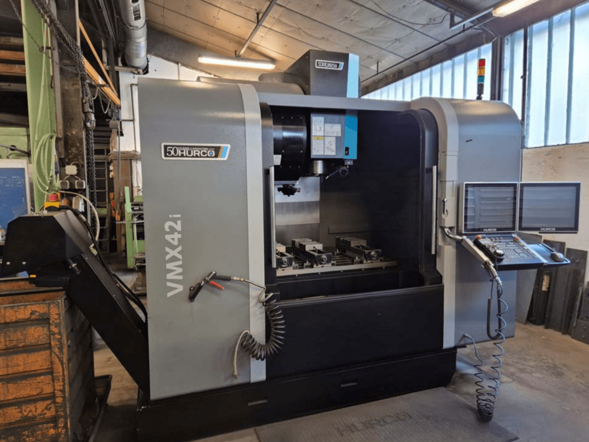 Centre d'usinage vertical Hurco VMX 42i, vue de face, montrant le panneau de commande et la zone de travail avec les étaux.