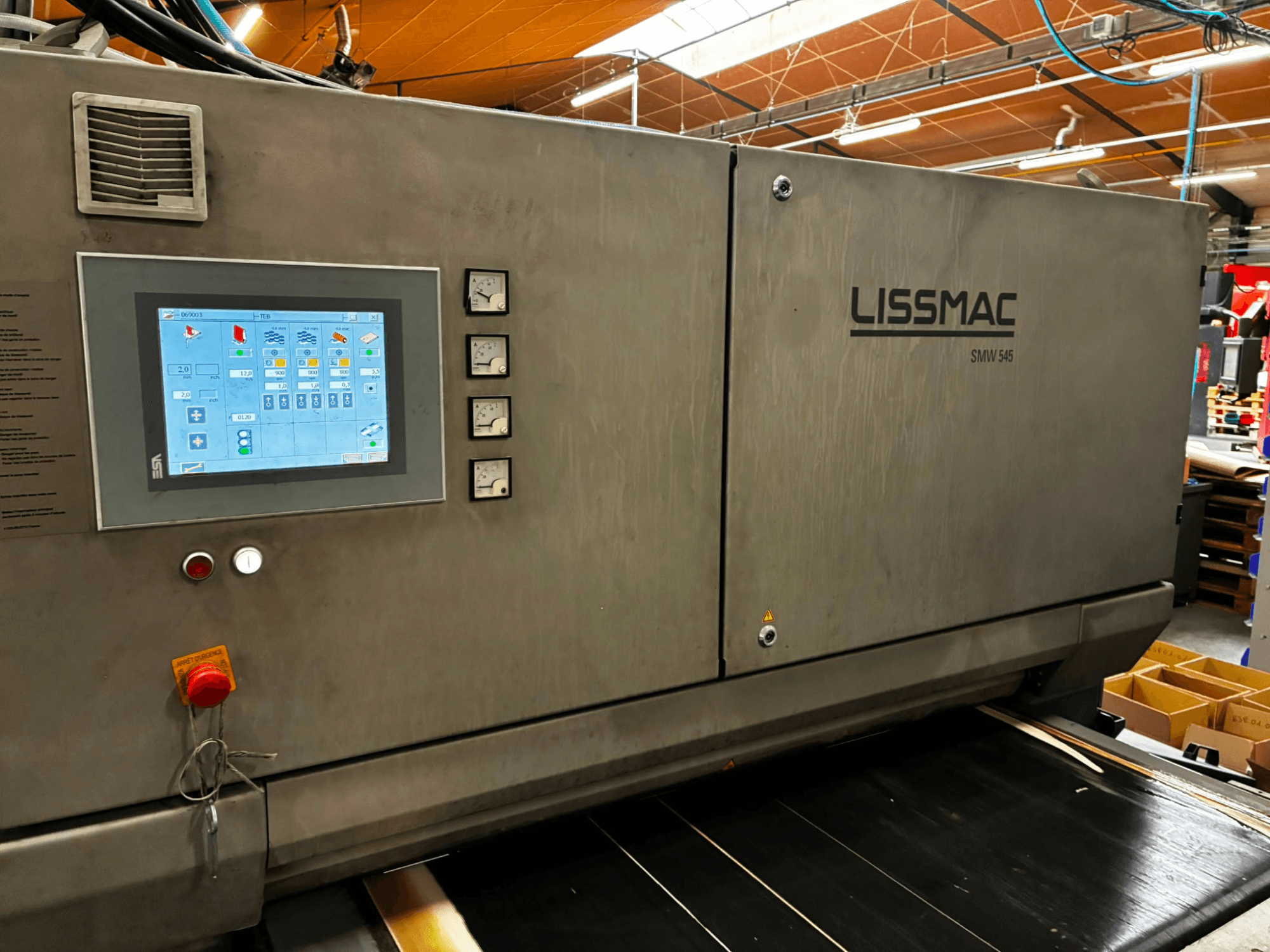 Machine d'ébavurage LISSMAC SMW 545 RTTB vue de profil, équipée d'un panneau de commande avec écran tactile et jauges.