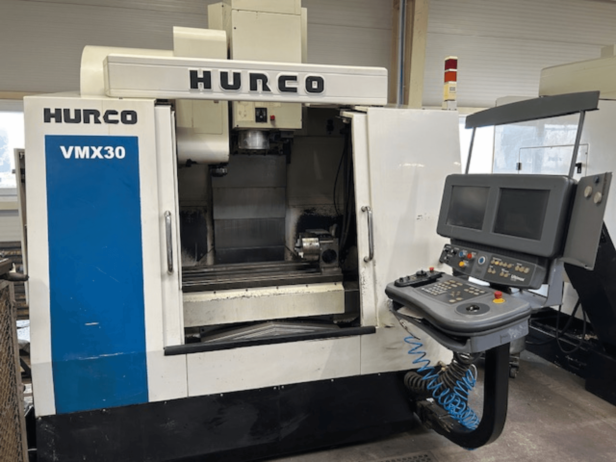 Fraiseuse CNC Hurco VMX30 dans un atelier, vue de face ; panneau de commande avec double écran et boutons de commande.