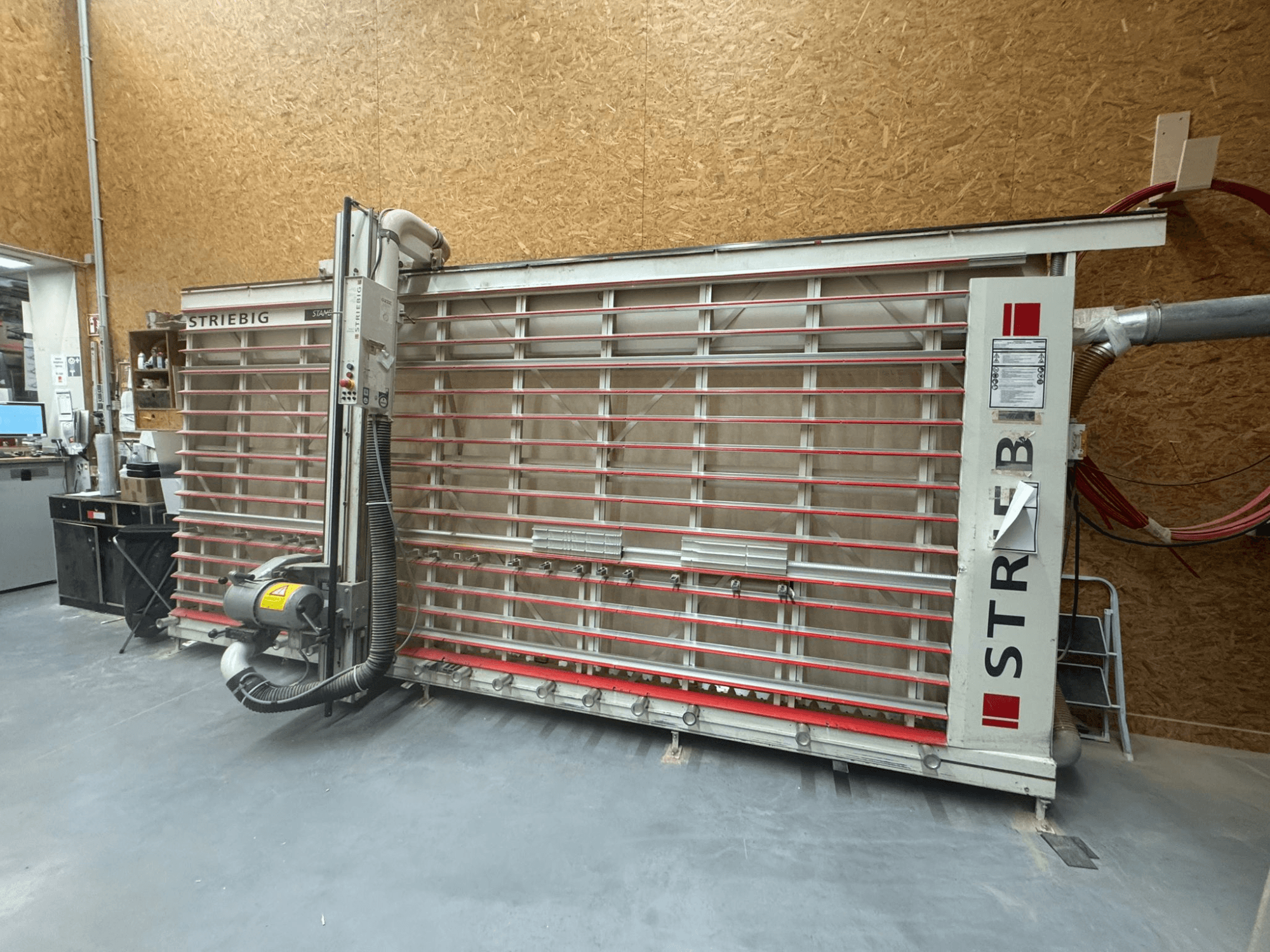 Scie à contour STRIEBIG avec une grande lame verticale, vue latérale montrant l'aspiration des poussières et le panneau de commande. Idéale pour le travail du bois.