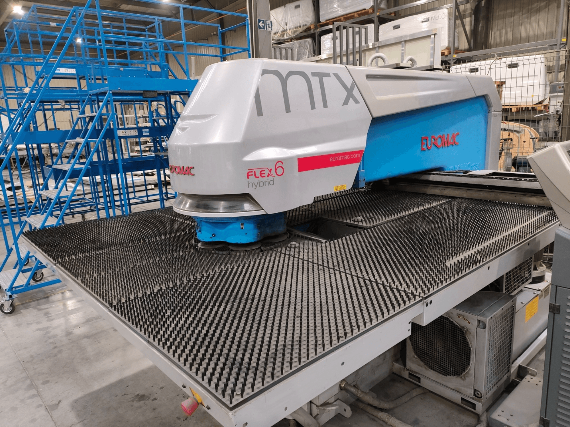 Vue de face d'une machine hybride Euromac FLEX 6 avec une surface de coupe texturée, installée dans un entrepôt.