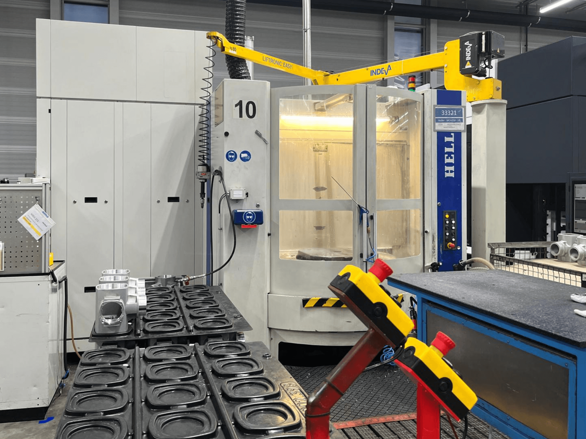 Centre d'usinage horizontal HELLER MCH 250 vu de face, avec des pièces en aluminium et des boutons de commande visibles sur le côté.