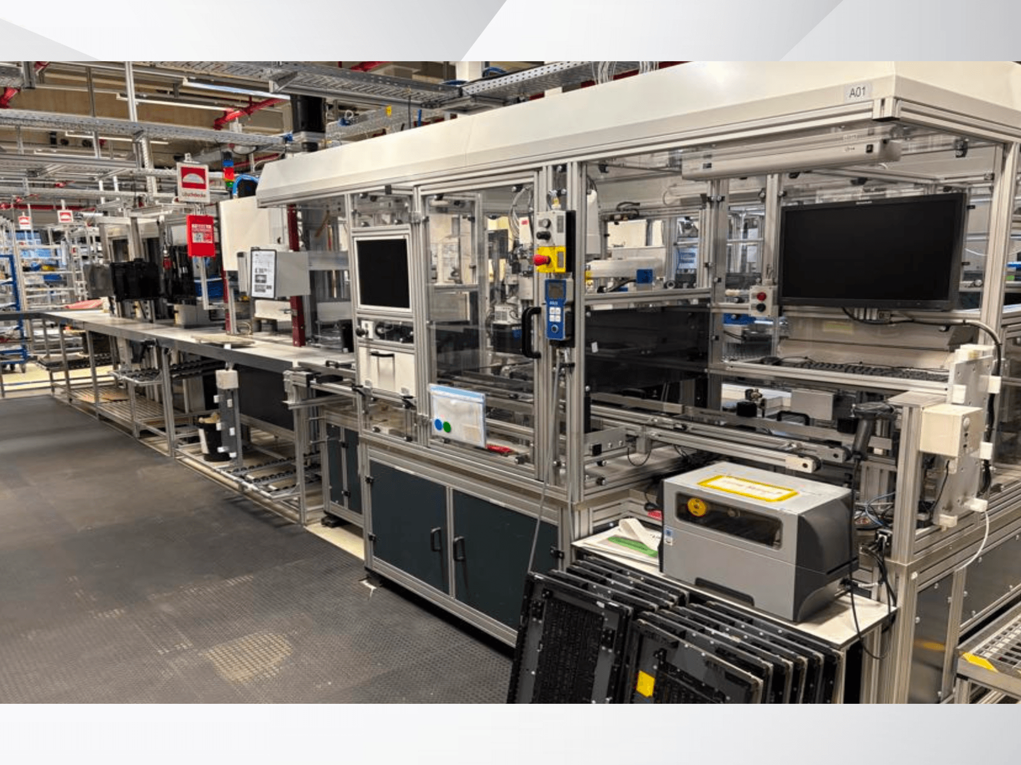Vue de profil de l'installation d'automatisation du système AMADA Jupiter, présentant les écrans, les panneaux de commande et les composants des machines.