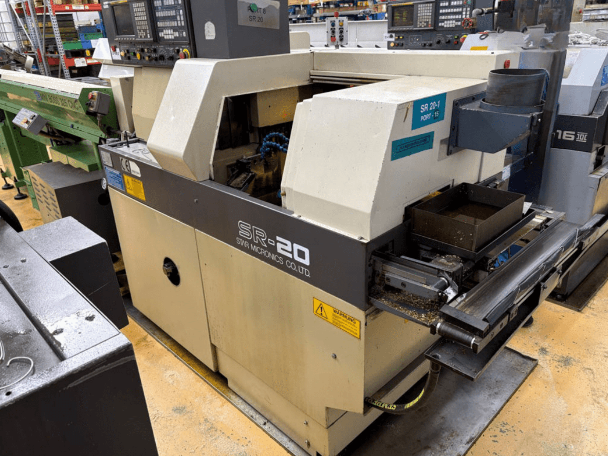Tour de type suisse STAR MICRONICS SR20 vu de profil, présentant le panneau de commande et la zone d'usinage avec des copeaux.