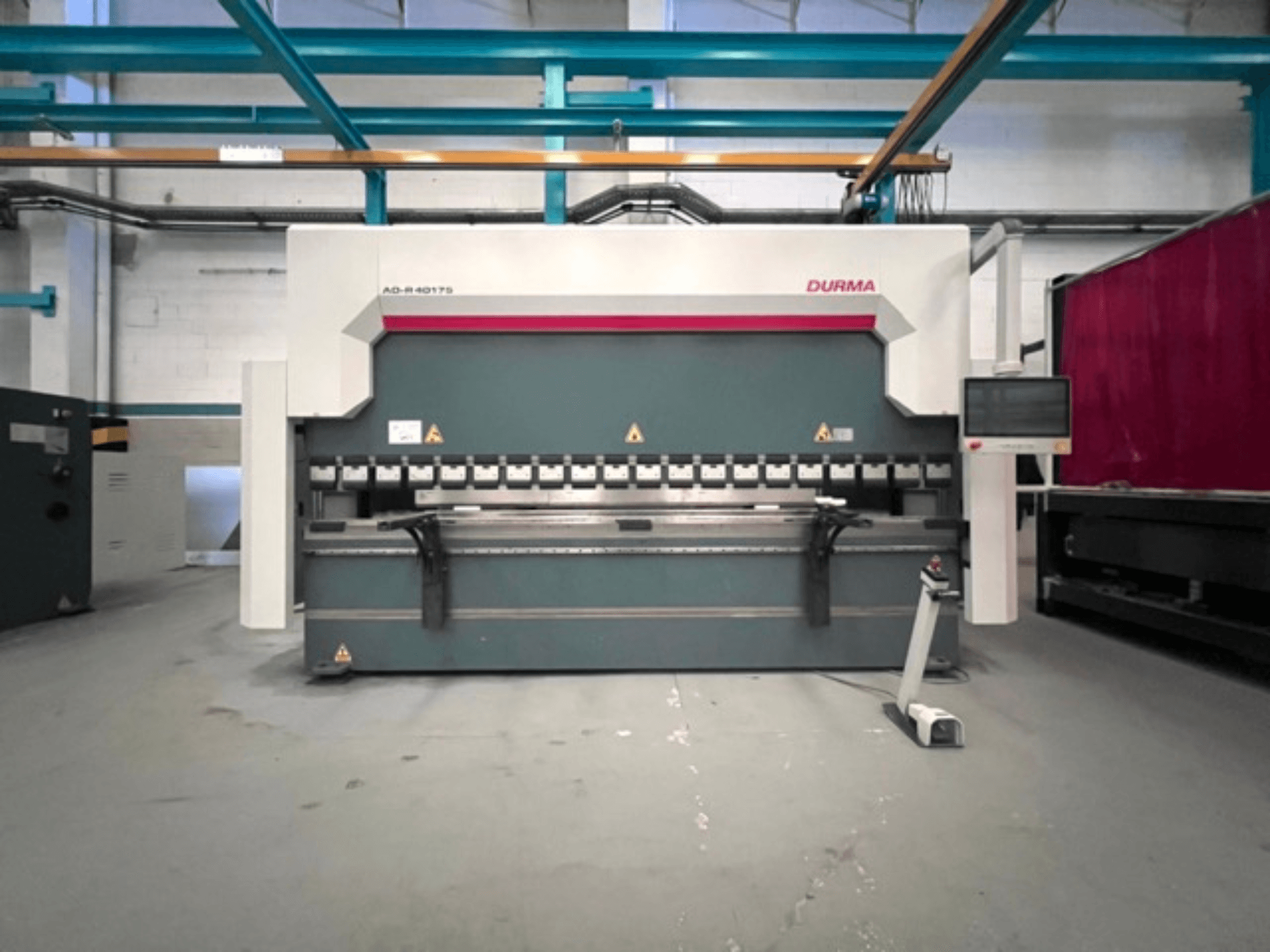 La presse plieuse Durma AD-R 40175, vue de face, comporte un panneau de commande et plusieurs mécanismes de pliage dans un atelier.
