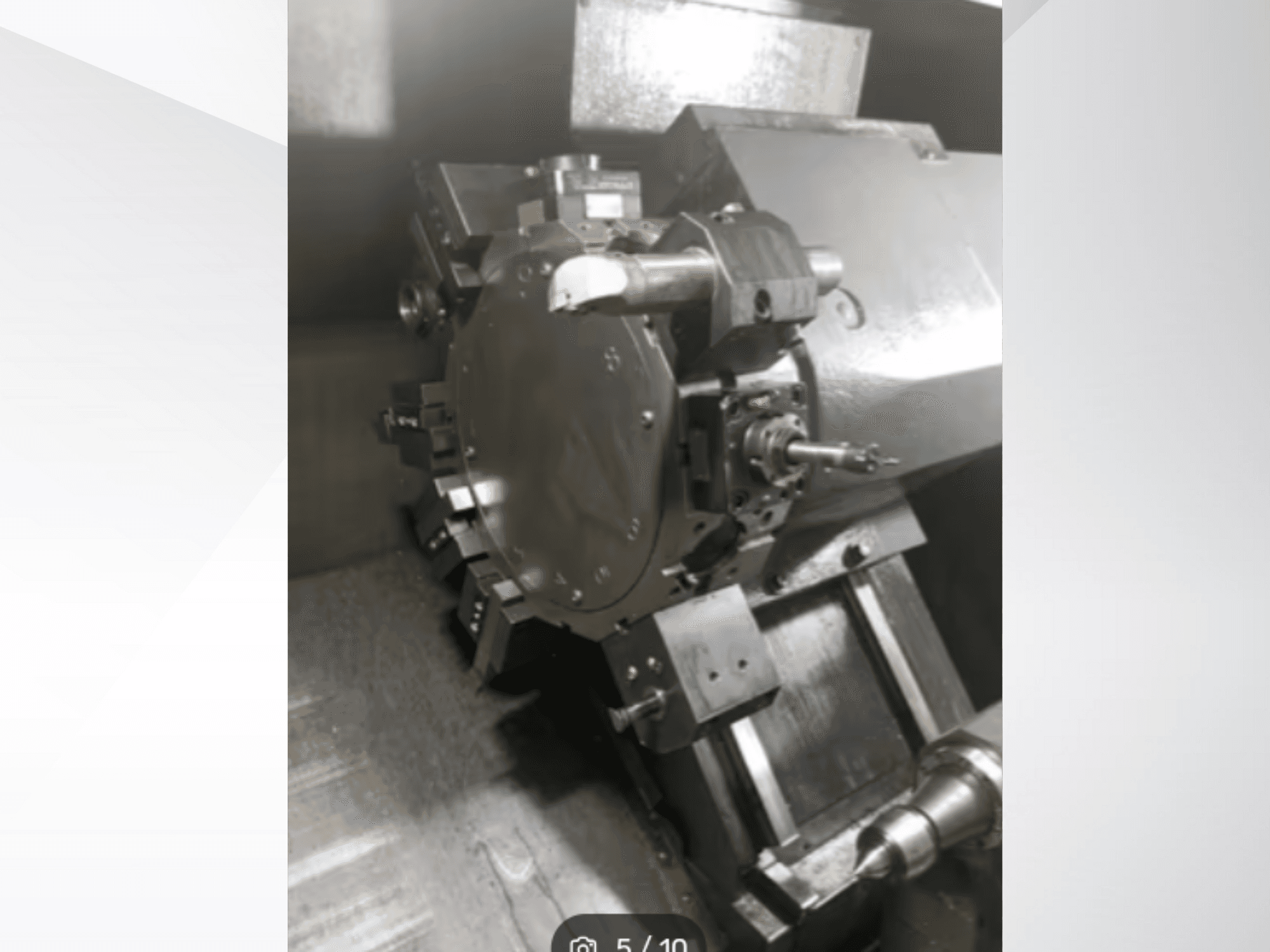 Gros plan d'une pièce de machine de précision, montrant des engrenages et des composants métalliques, vue de biais. Aucune marque n'est visible.