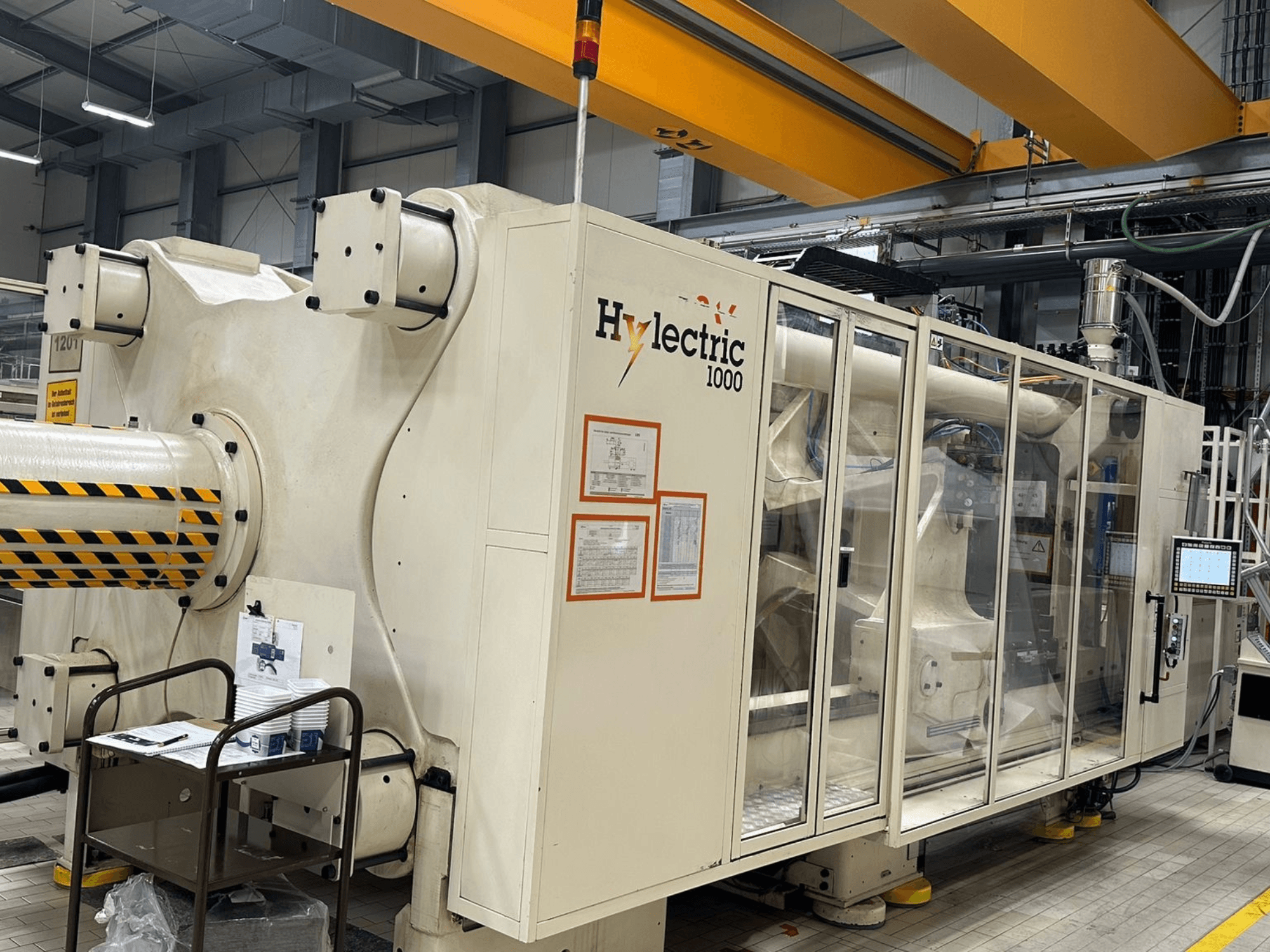 Presse à injection électrique Husky Hylelectric H1000 RS95/80, vue de profil montrant le panneau de commande et les dispositifs de sécurité.