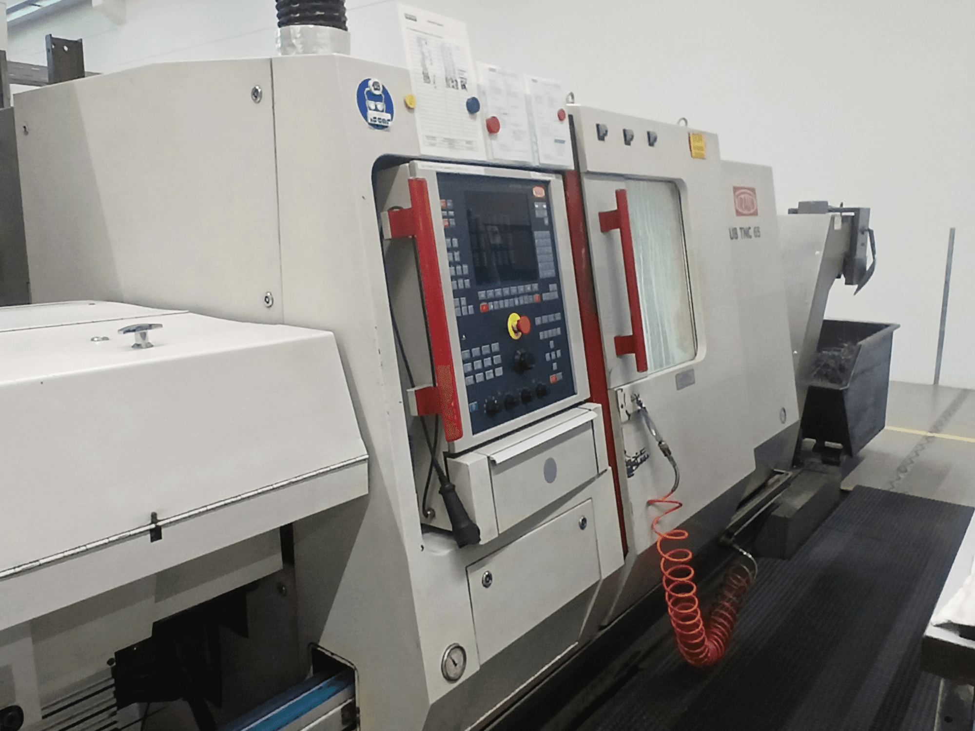 Tour horizontal TRAUB TNC65 DG, vue de face, montrant le panneau de commande et les outils, idéal pour l'usinage de précision.