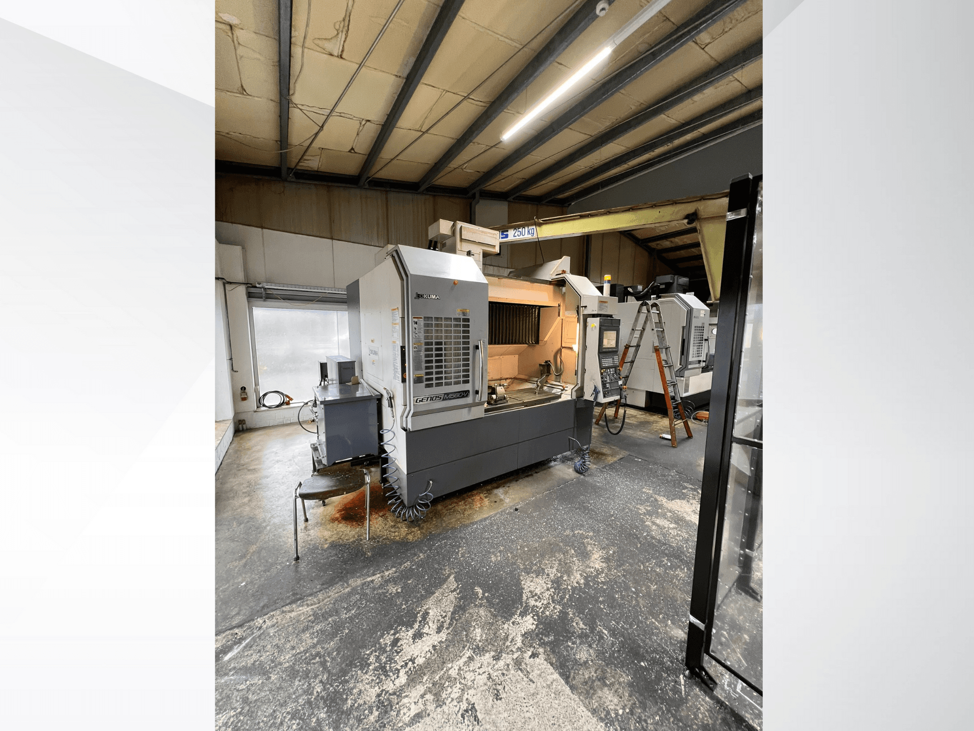 Machine CNC GRETOS 750 dans un atelier, vue de face, montrant le panneau de commande et la zone de travail avec les outils, échelle visible à l'arrière-plan.