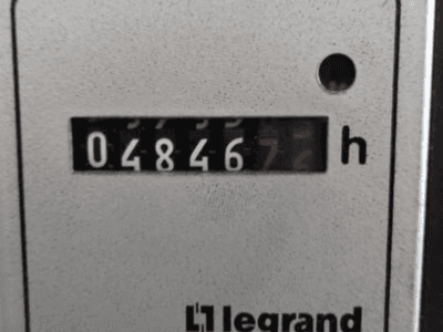 Compteur horaire Legrand indiquant 048467.6, vue de face avec voyant rouge et chiffres noirs sur fond clair texturé.