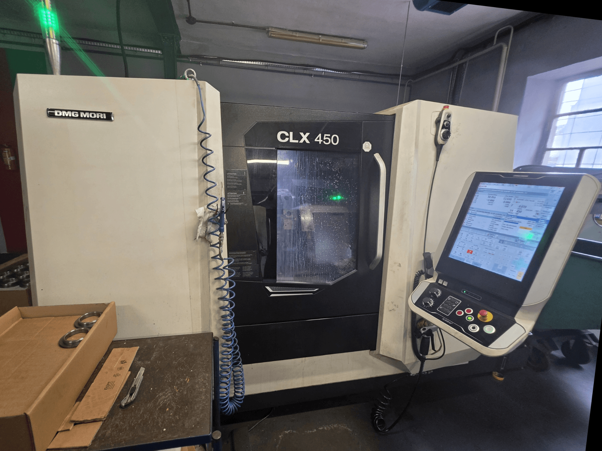 Vue de face du tour horizontal DMG MORI CLX 450 V3, montrant le panneau de commande, le système de refroidissement et la zone de travail.