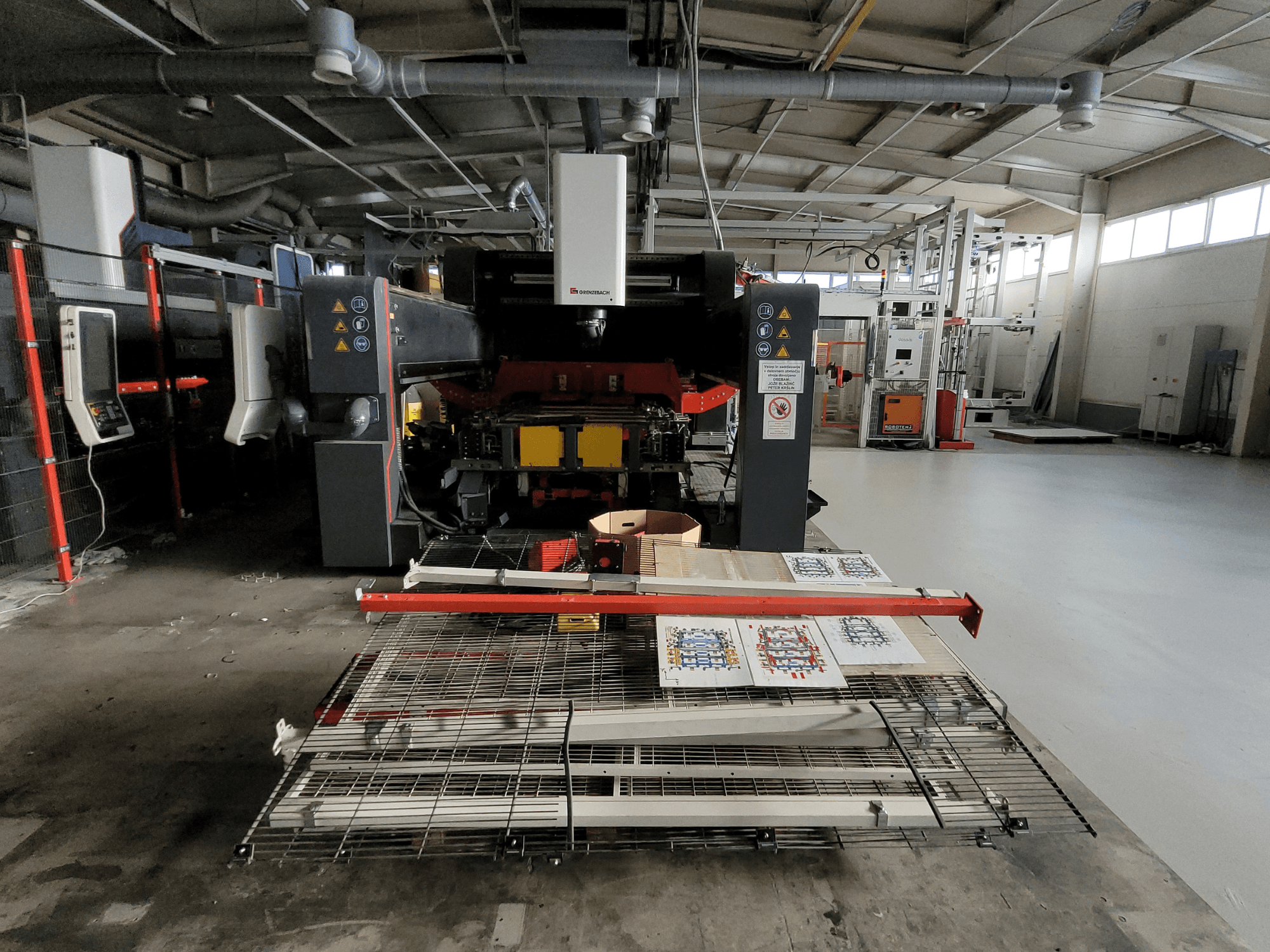 La machine FSW DSM 2400 de GRENZEBACH, vue de face dans sa configuration d'usine, présente le dispositif d'usinage avec les matériaux imprimés et l'équipement.
