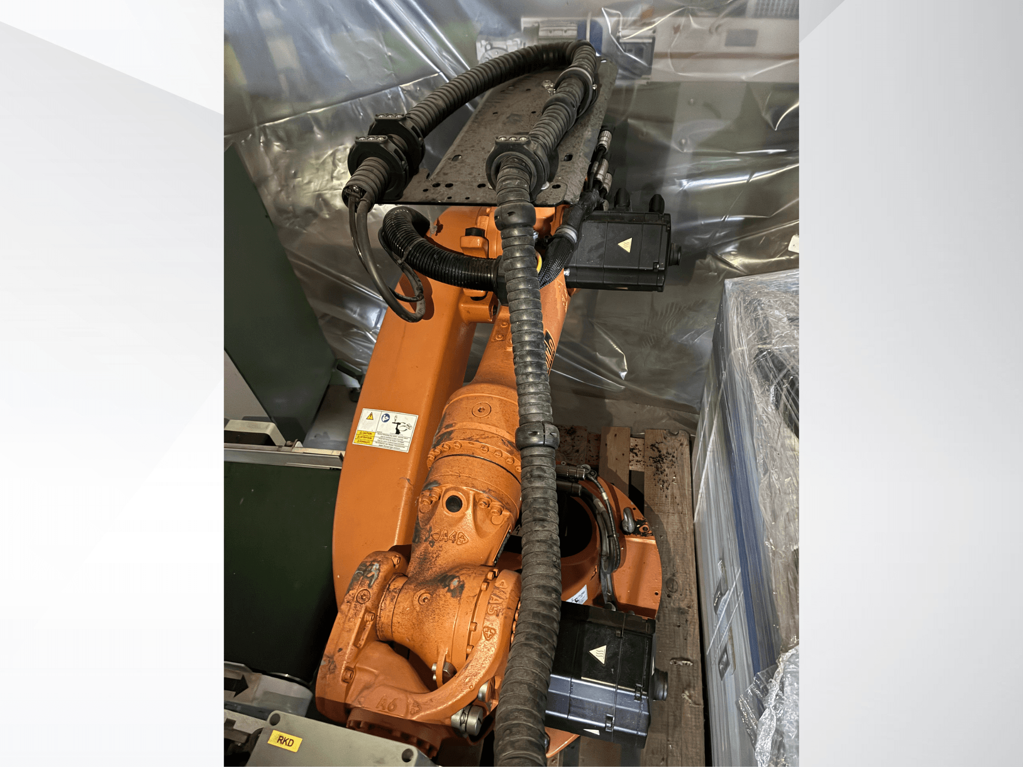 Bras robotisé KUKA KR16-2 de couleur orange, vu de dessus, mettant en évidence les connecteurs et les gaines de protection.