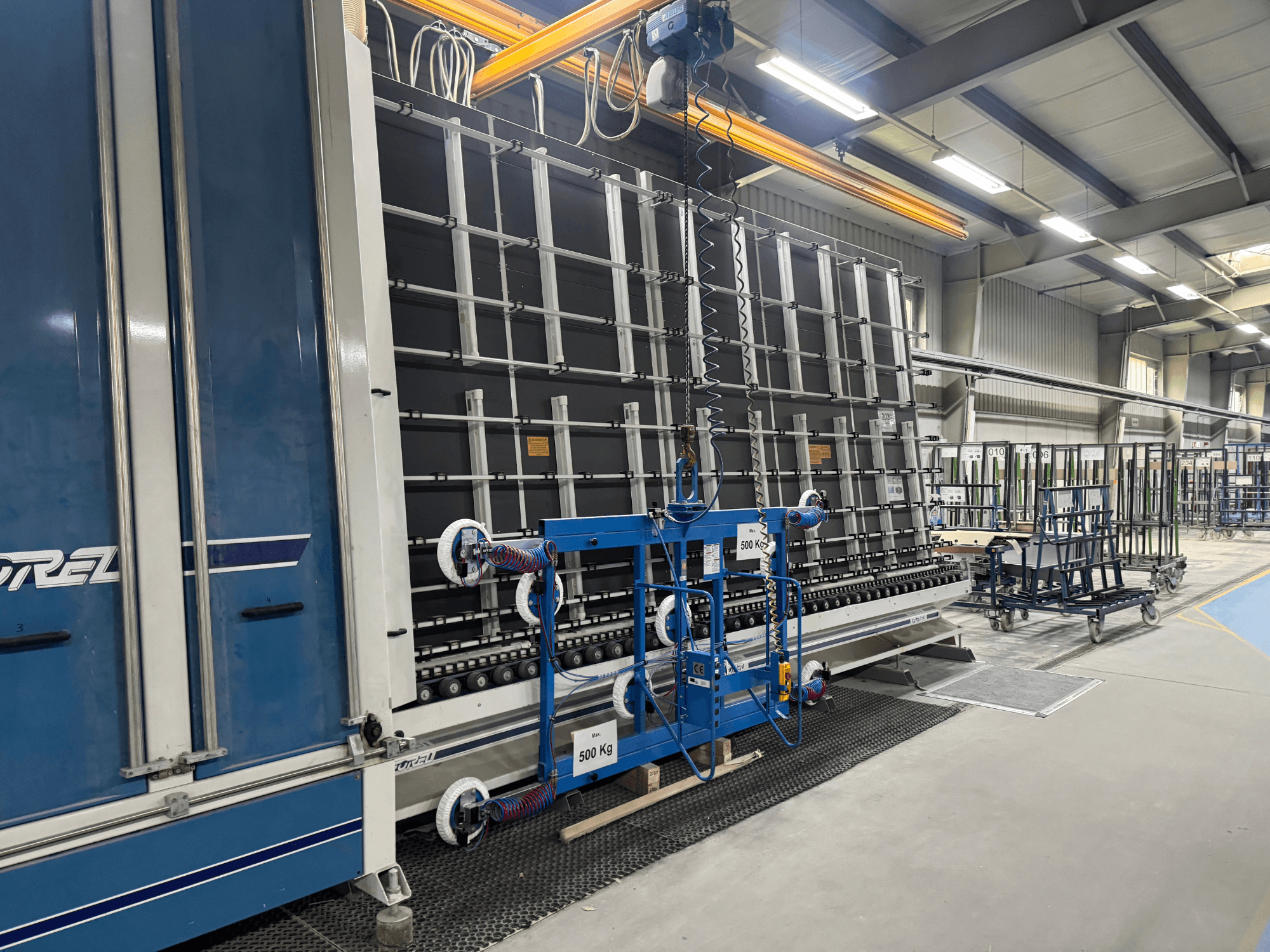 Équipement industriel de Drel, composé d'un grand cadre et d'un mécanisme de levage, présenté en vue latérale dans une usine.