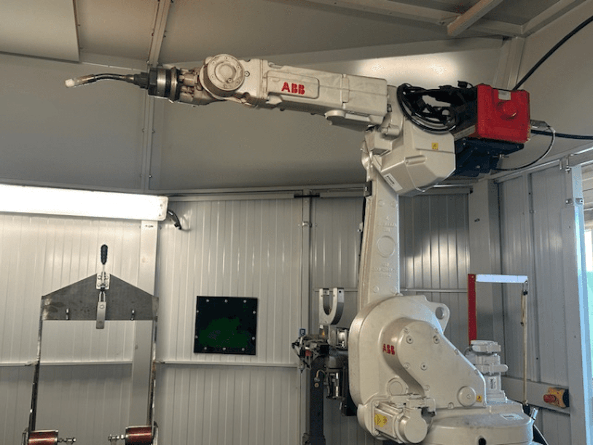 ABB Schweißroboter Flex Arc - vue latérale d'un bras robotisé avec un outil de soudage, présentant des détails tels que le panneau de commande et les câbles.
