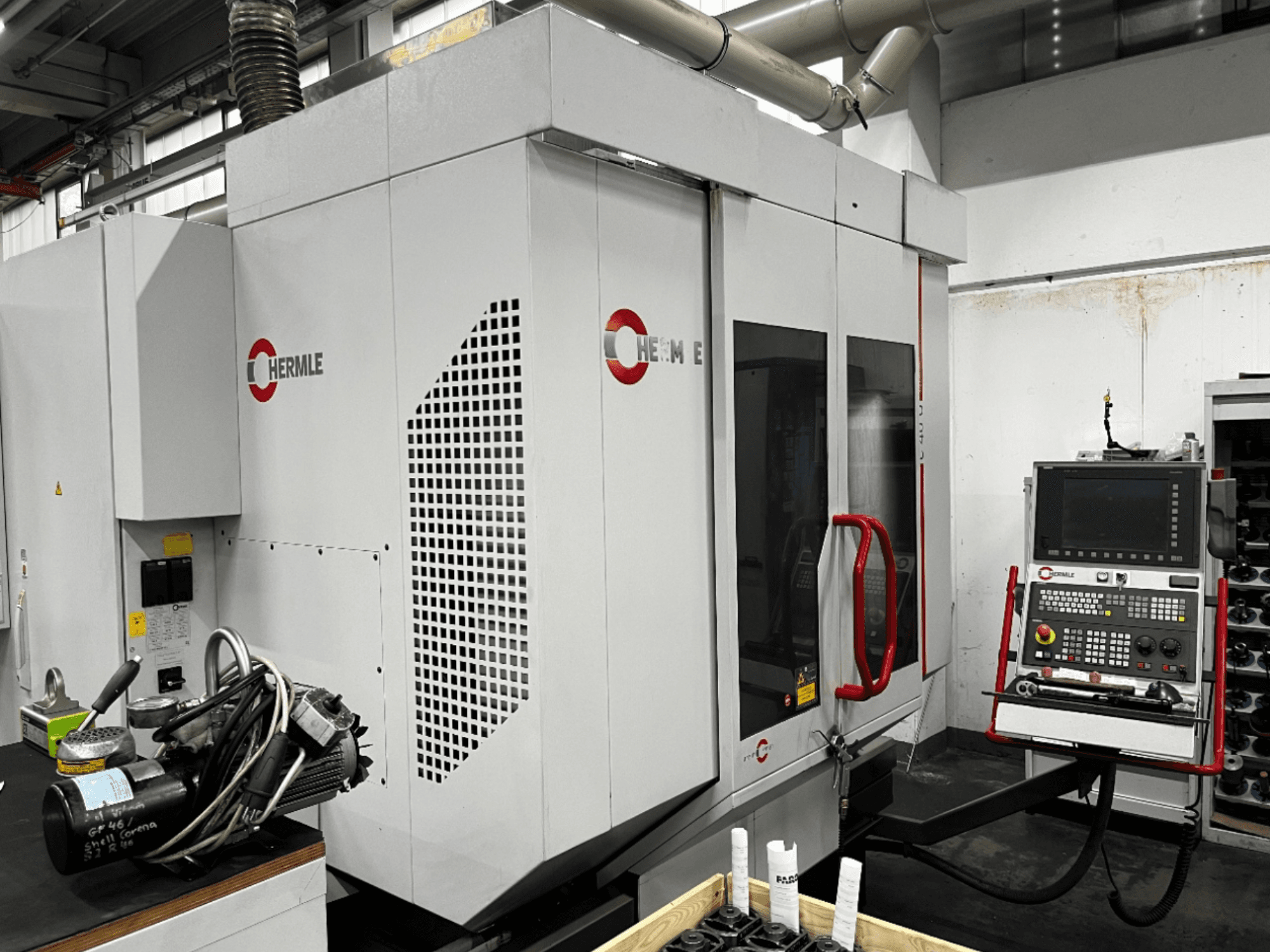 Centre d'usinage universel HERMLE C40U dans un atelier, vue de face, montrant le panneau de commande et la conception détaillée de la machine.