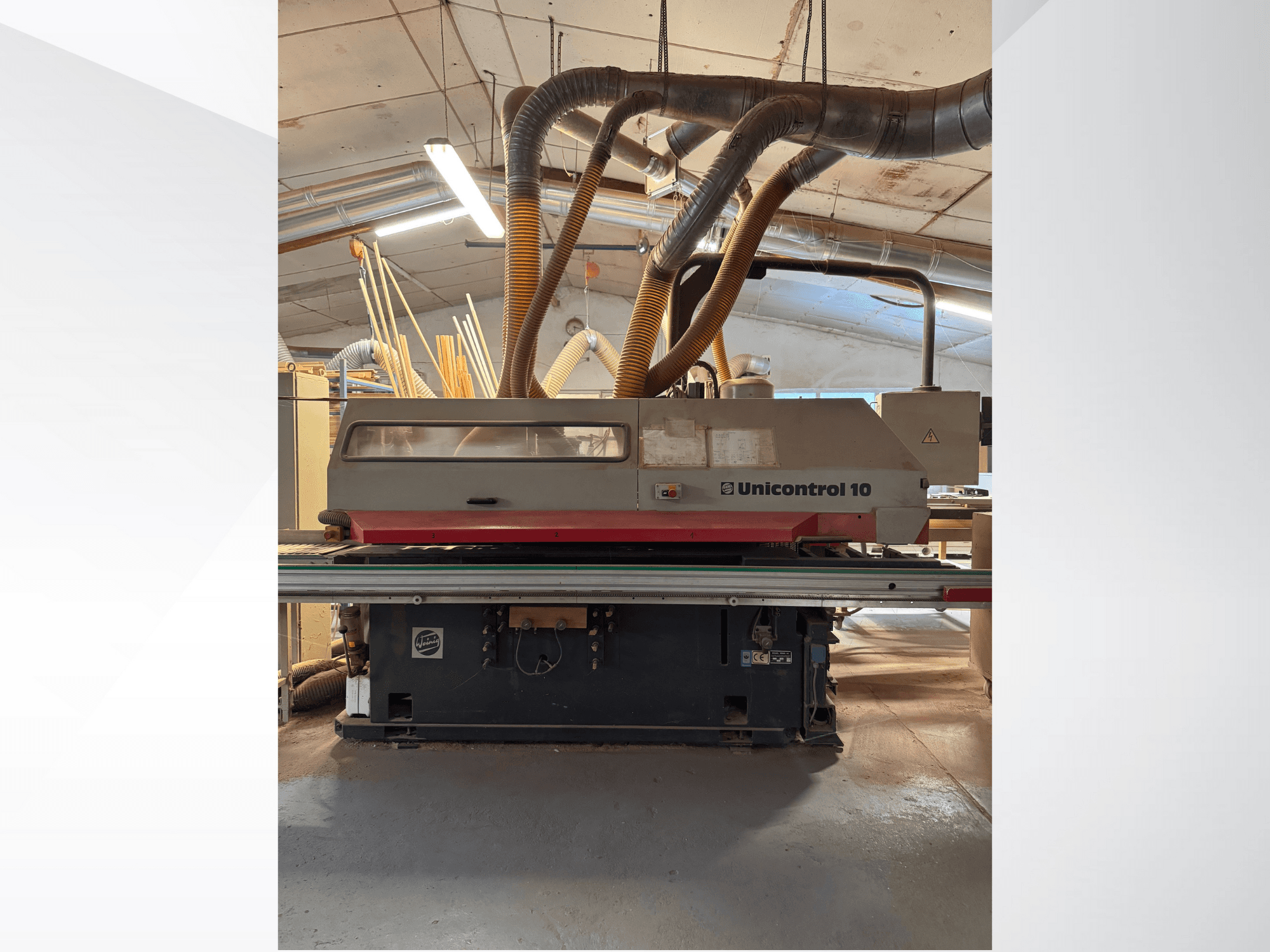 Vue avant d'une machine à travailler le bois Unicontrol 10, avec tubes d'extraction de la poussière et commandes opérationnelles.