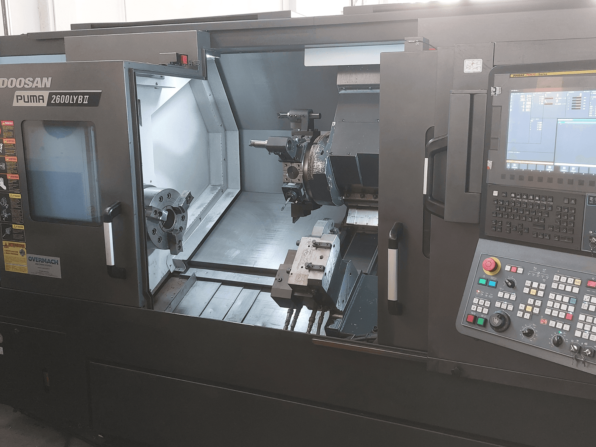 Tour horizontal DOOSAN Puma 2600 LYB II en vue de face, montrant l'intérieur avec le mandrin, le porte-outil et le panneau de commande.