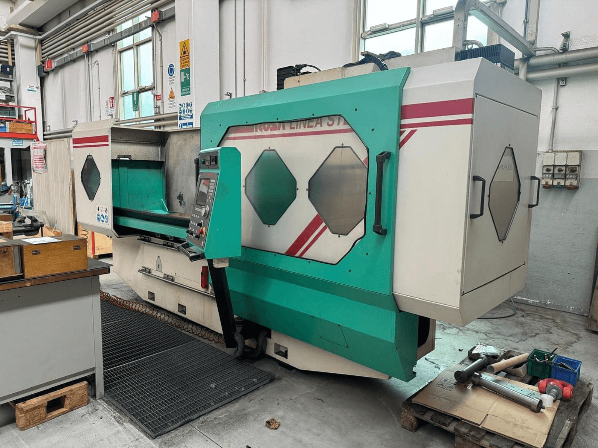 Machine de précision verte et blanche, vue de face, avec panneau de commande, zone de travail et outils sur une palette. Marque : BAMB.