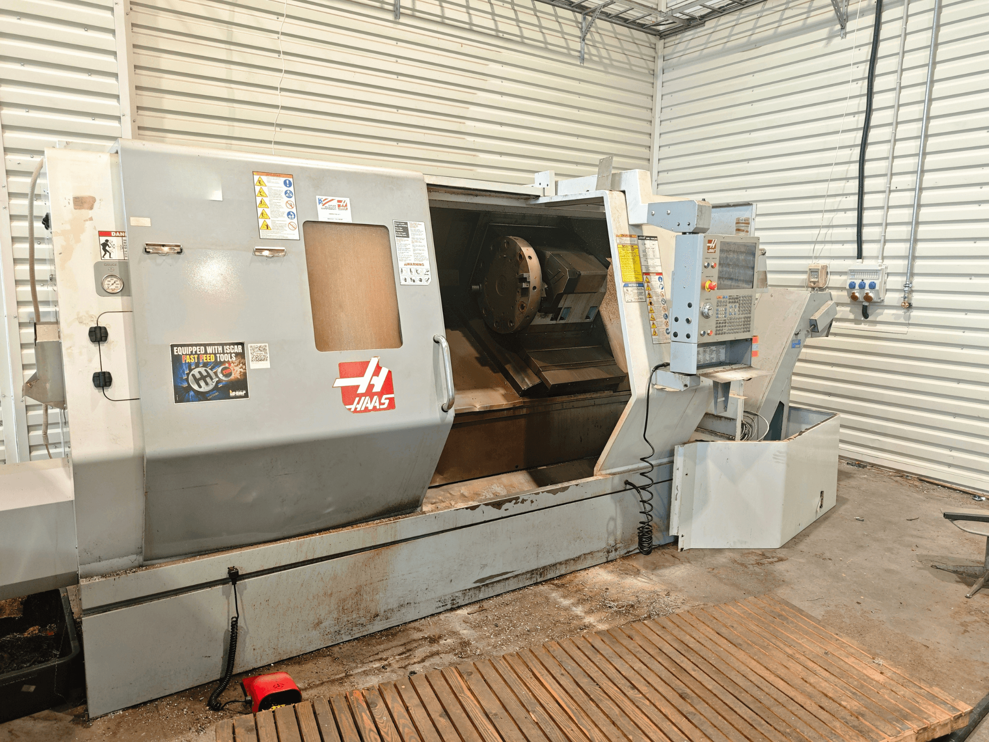 Tour horizontal Haas SL-40HE, vue de face, montrant le panneau de commande, la zone de travail et les étiquettes de sécurité.