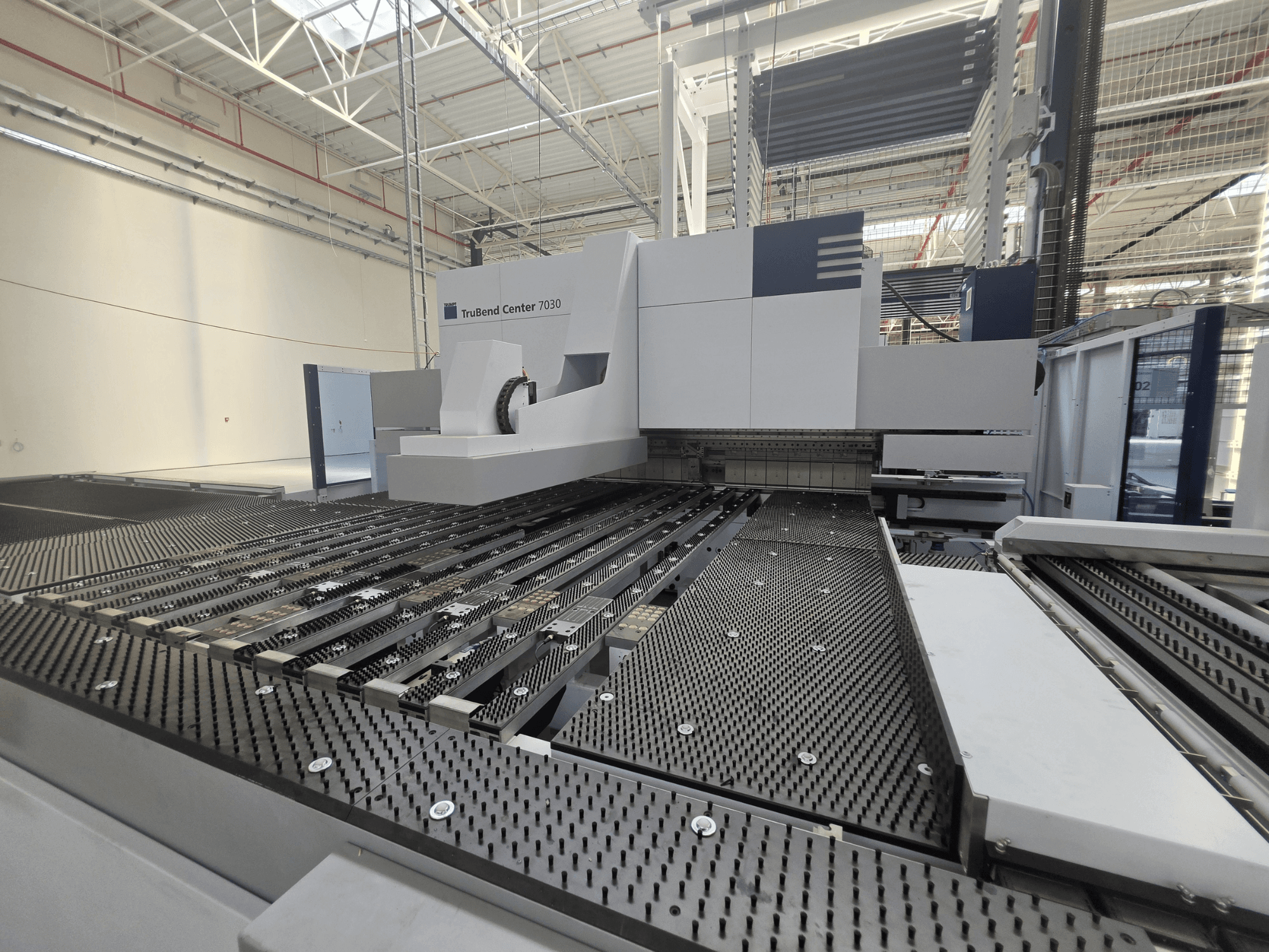 Plieuse TRUMPF TruBend Center 7030 dans un environnement d'usine, vue de face montrant la table de travail sophistiquée et le bras de pliage.