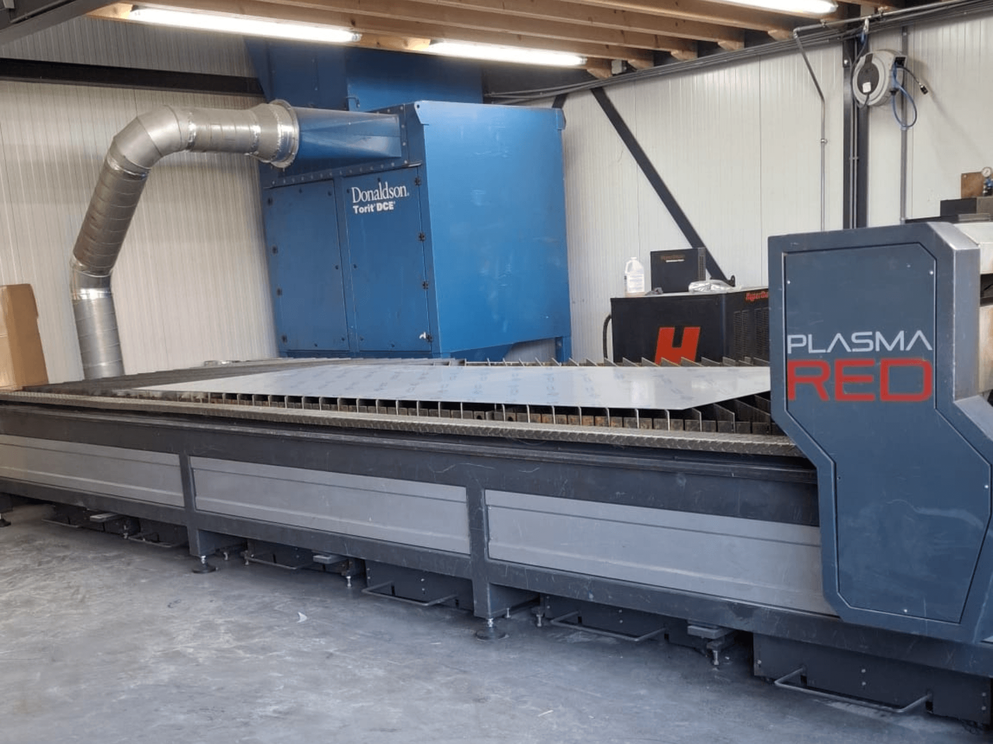 Machine de découpe plasma SOITAAB Plasmatech-Red vue de face, dotée d'une large table de découpe et d'un système d'échappement.