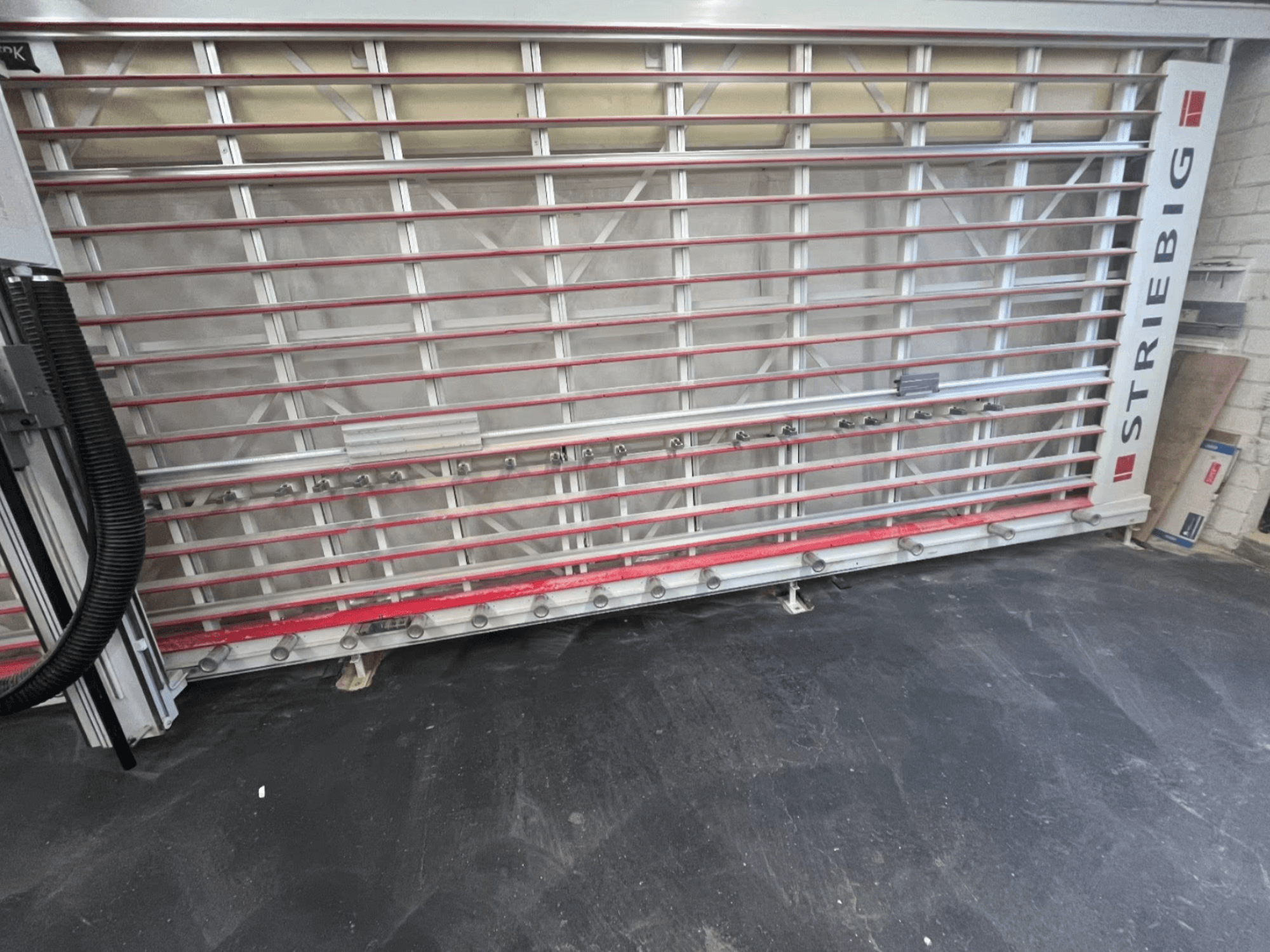 Scie à panneaux STRIEBIG Standart II TKR 6220A vue de l'avant ; elle présente un châssis métallique avec des rails rouges et des éléments de coupe.