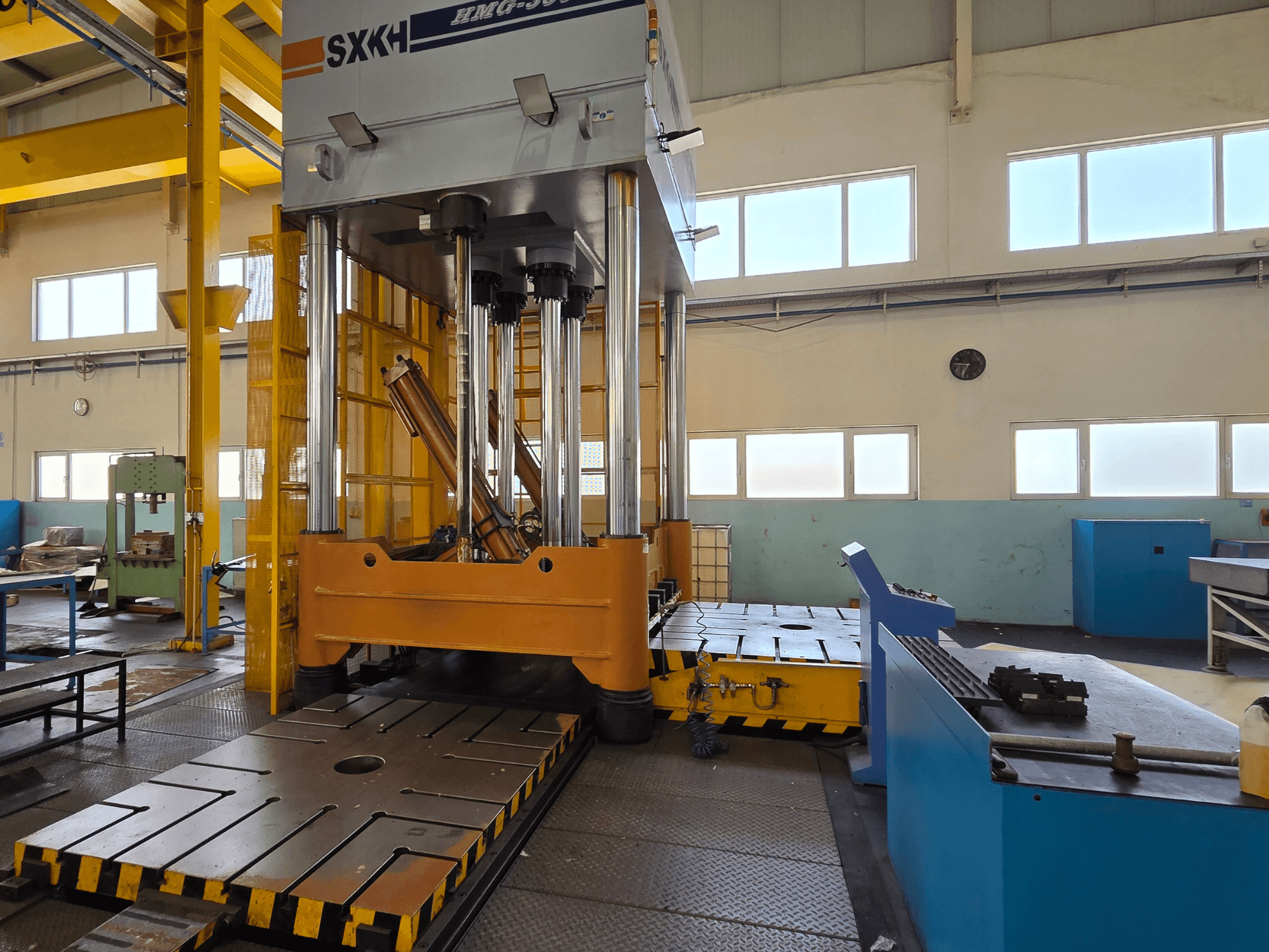 Presse hydraulique SXKH HMG-300JM vue de face, dotée de grands cylindres de pressage et d'une base robuste dans une usine.