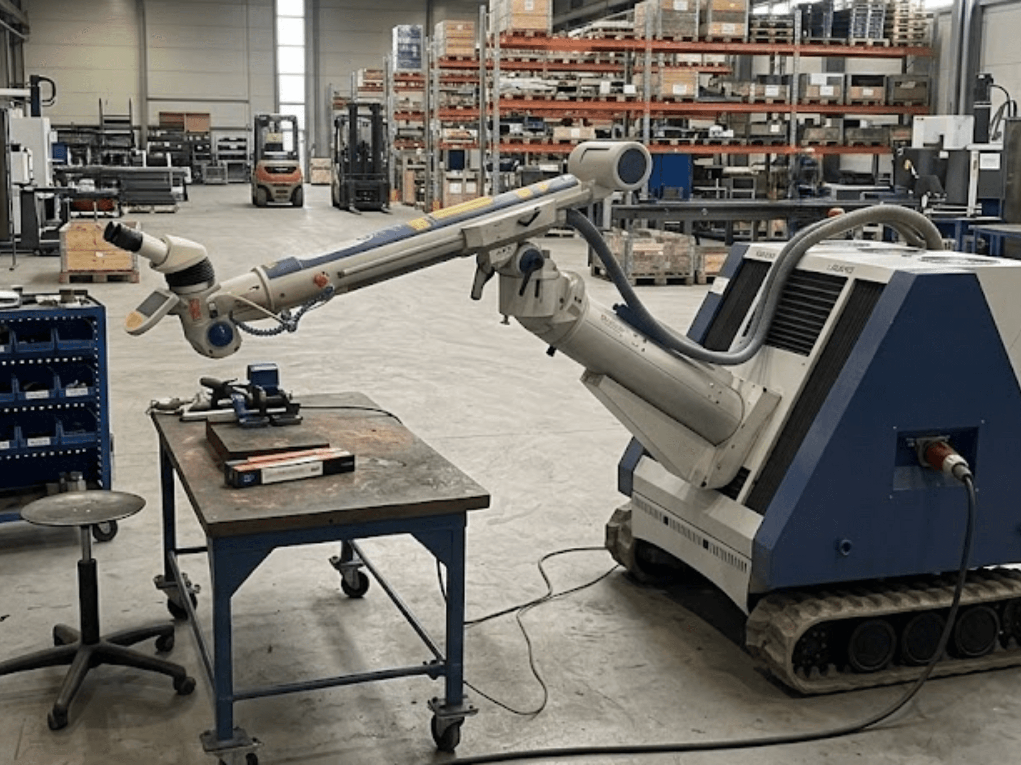 Machine-outil ALPHA LASER ALFlak300 M dans un atelier équipé d'un bras robotisé, vue de face mettant en évidence le réglage de précision sur la table de travail.