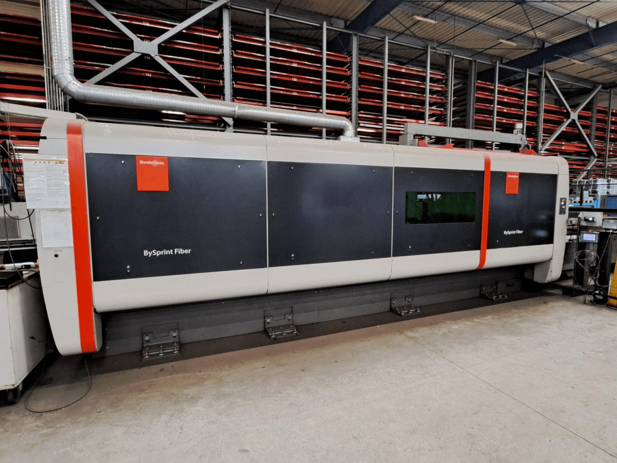 Machine de découpe laser à fibre Bystronic BySprint Fiber 4020, vue de face dans un atelier avec les dispositifs de sécurité visibles.