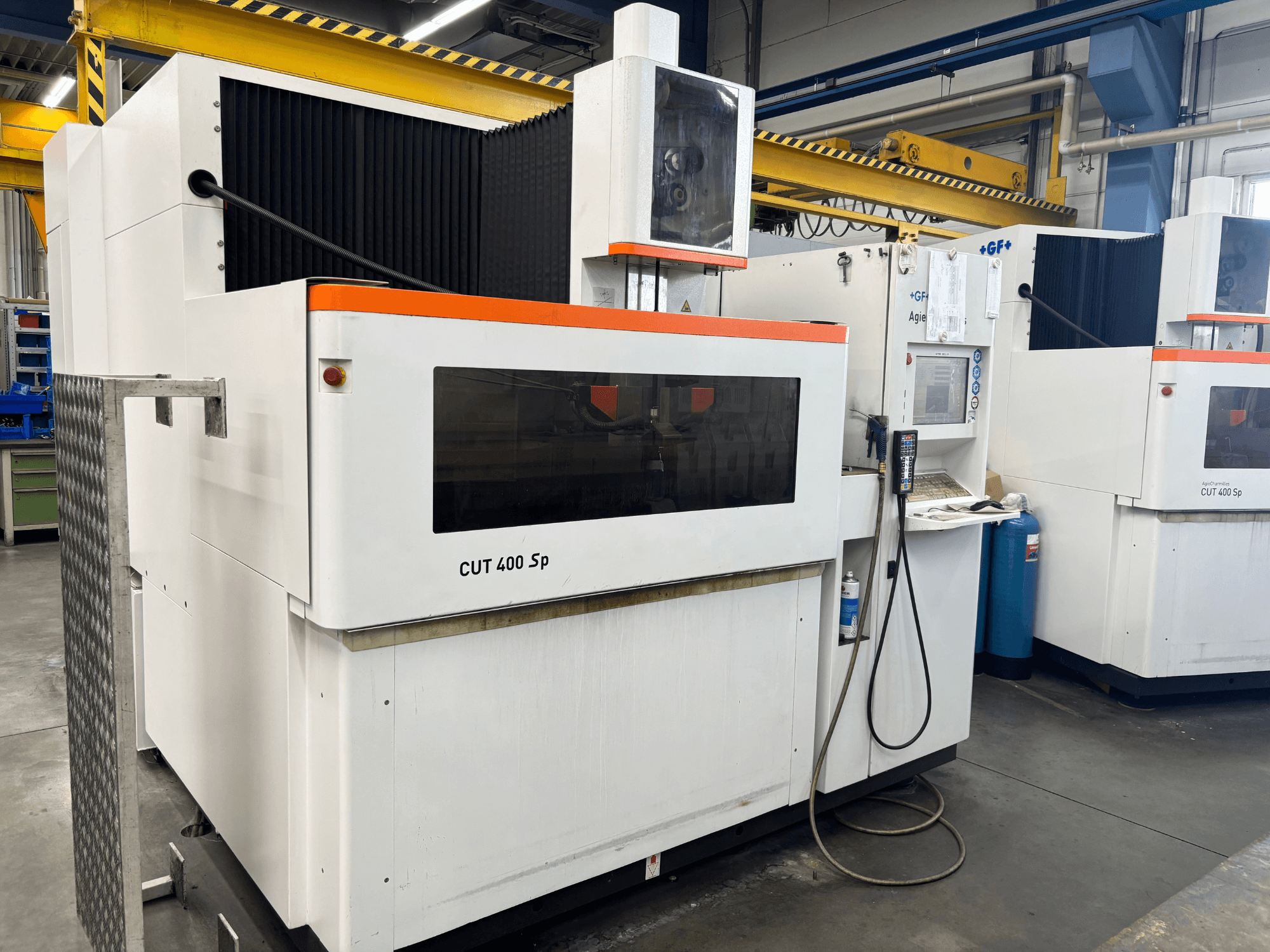 Machine d'électroérosion à fil +GF+ AGIECHARMILLES CUT 400 Sp, vue de face, avec panneau de commande et système de refroidissement intégré.