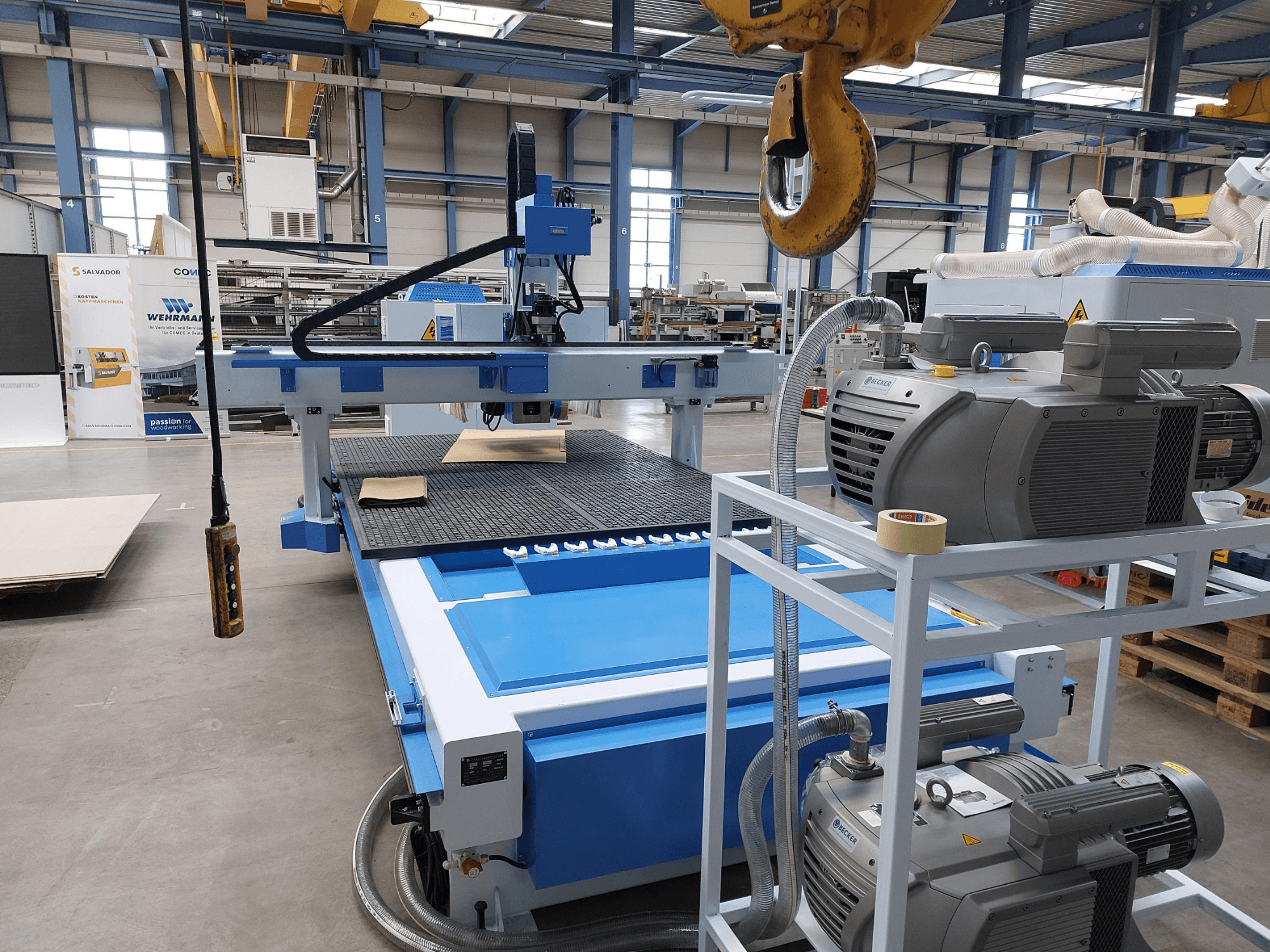 Centre d'usinage CNC QUICK CNC UA 481 : vue de face montrant le panneau de commande, les moteurs et la surface de travail avec une pièce en bois.