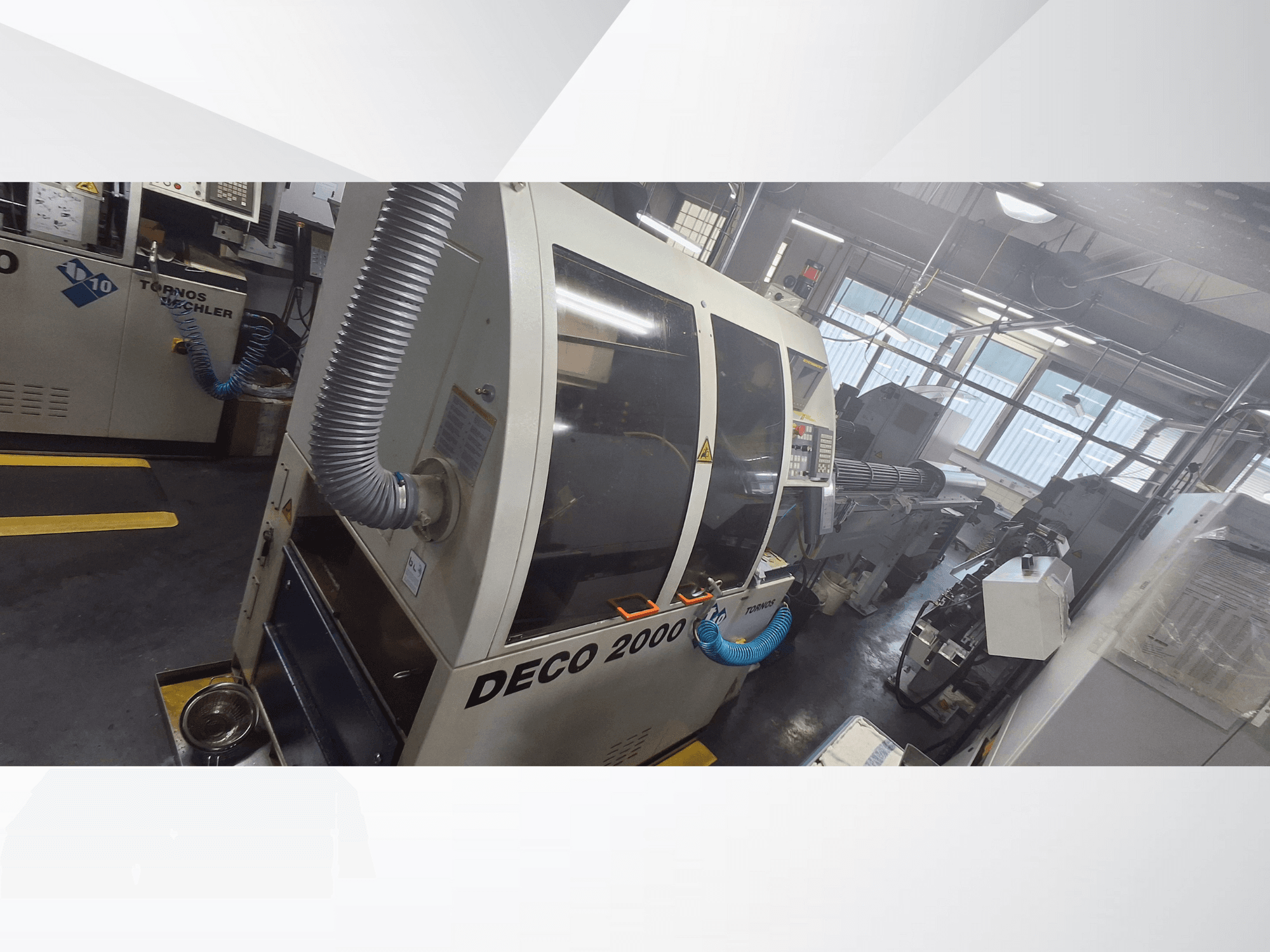 Machine CNC DECO 2000 dans l'atelier, vue de face, avec tuyau de ventilation et panneau de commande, conçue pour l'usinage de précision.