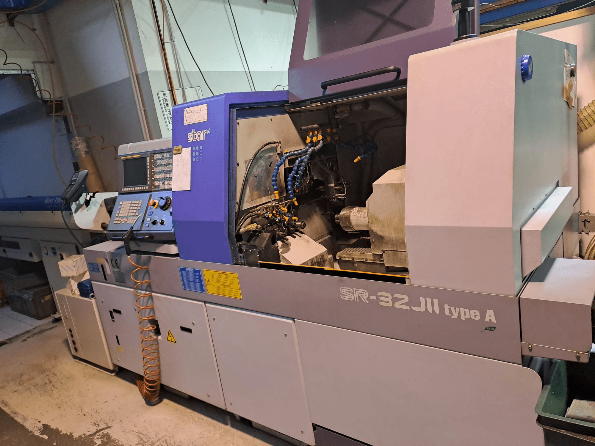 STAR MICRONICS SR-32JII-typeA Swiss Type Turning Machine vue de côté, avec le panneau de commande et les composants d'usinage visibles.