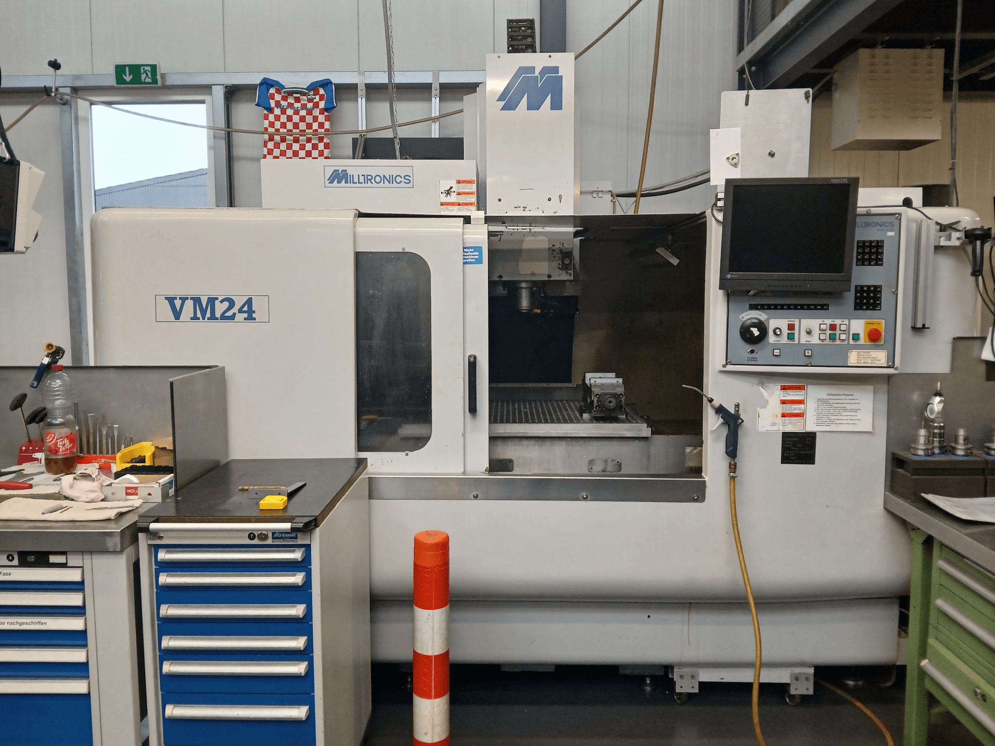 Fraiseuse Milltronics VM24 CNC présentée de face, avec panneau de commande, rangement des outils et aménagement de l'espace de travail.