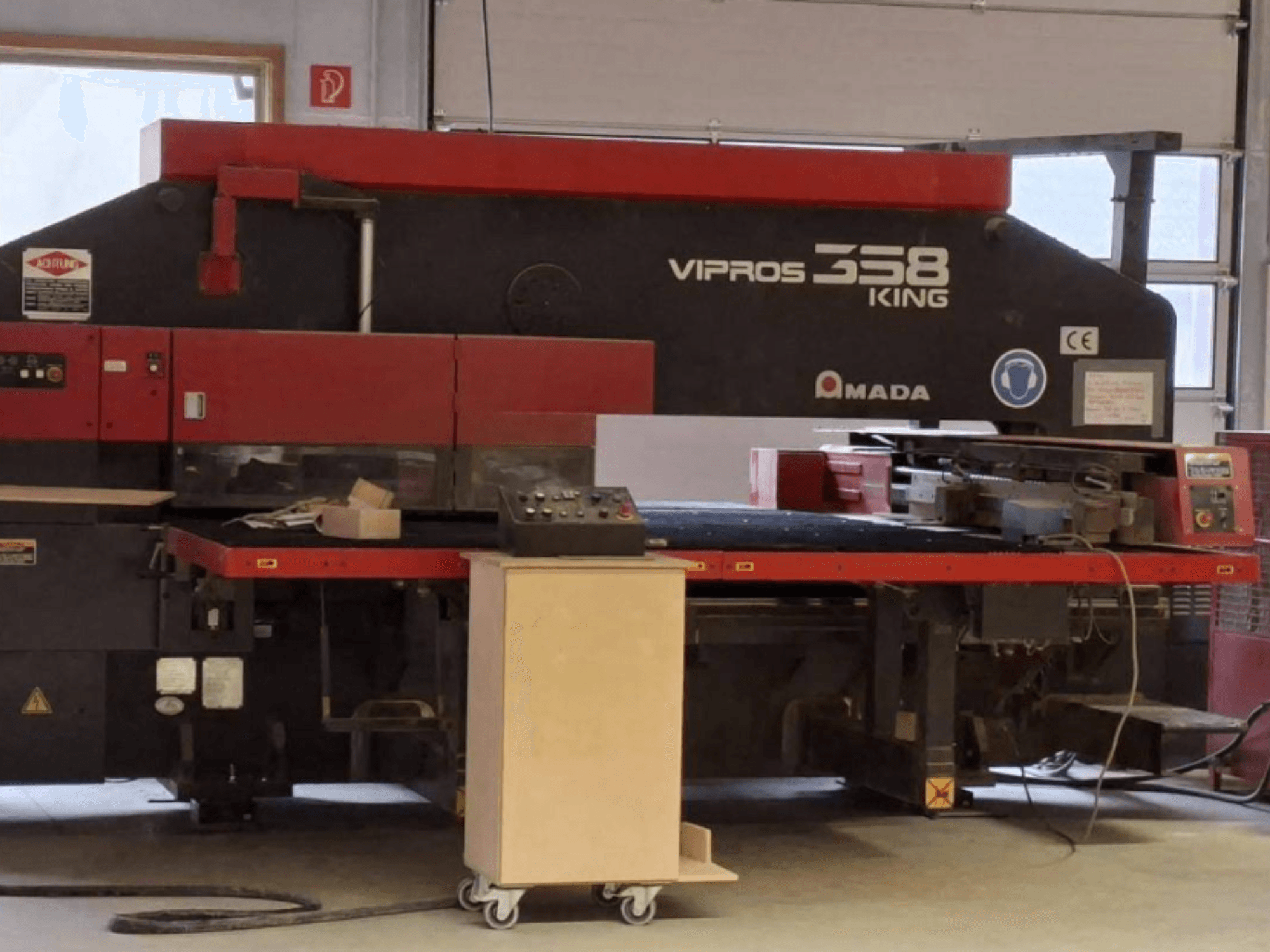 Poinçonneuse CNC AMADA VIPROS 358 KING vue de profil, avec le panneau de commande et la zone de rangement des outils.