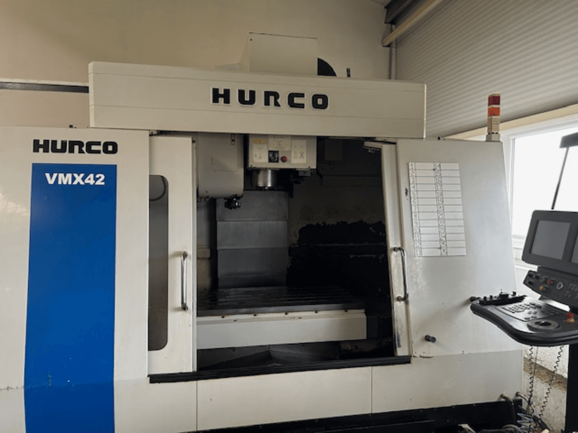 Machine CNC Hurco VMX42 vue de face, montrant le panneau de commande, la broche et la zone de travail ; révélant la disposition opérationnelle.