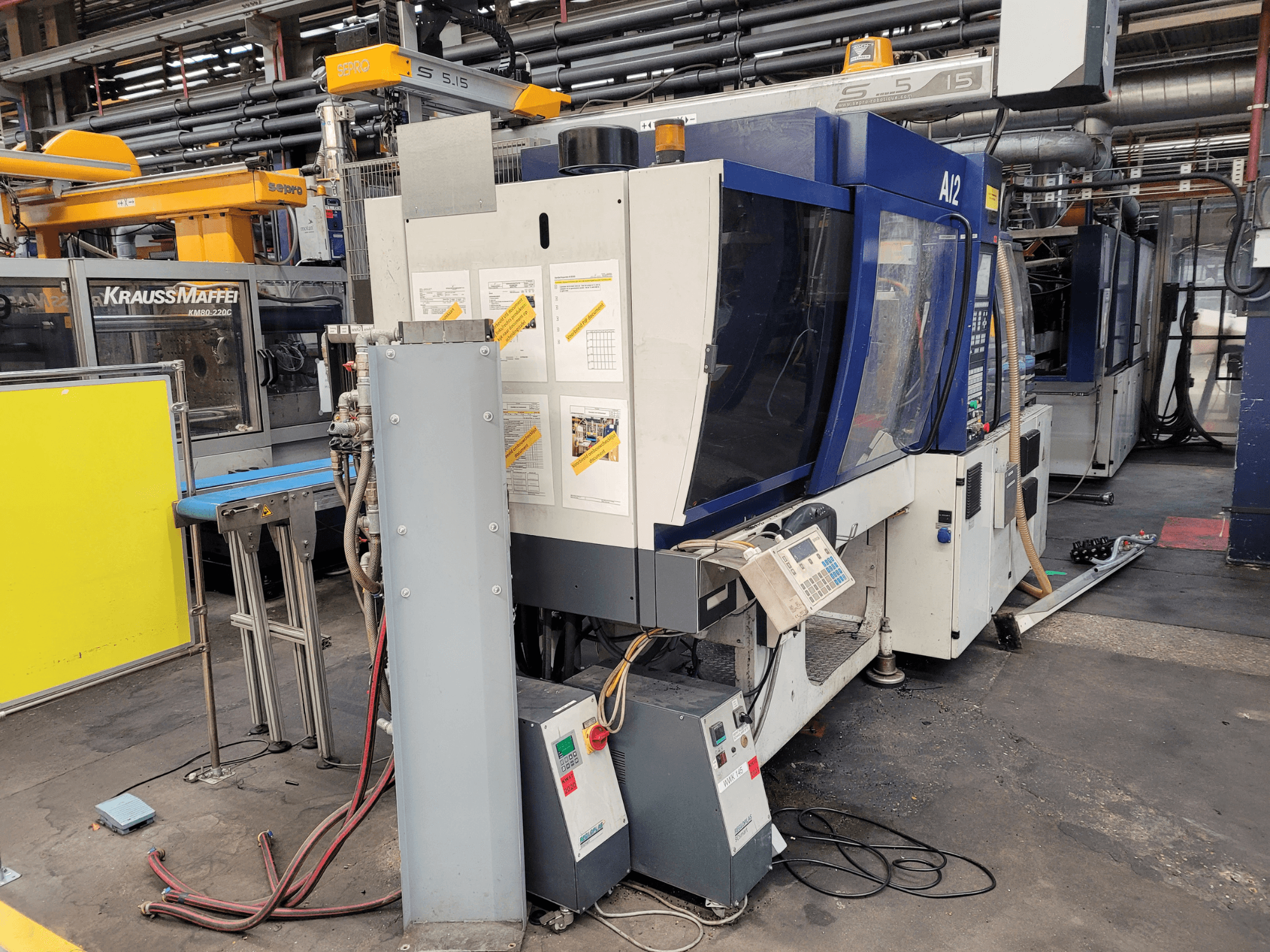 Machine de moulage par injection KraussMaffei, modèle KM80-232G, vue de face, avec panneau de commande et composants opérationnels.