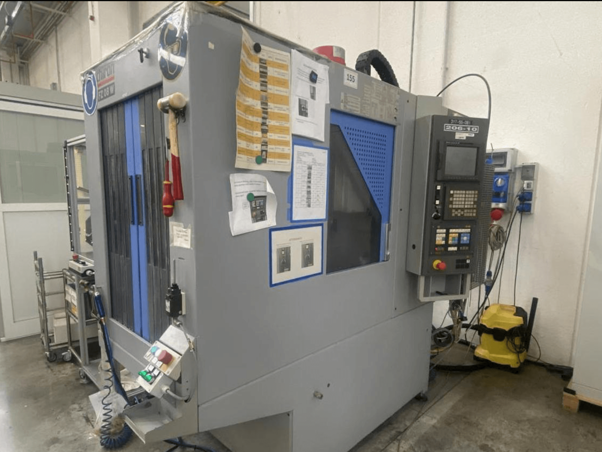 Machine CNC de Shin Lin, vue de face, avec panneau de commande, boutons de commande et instructions de sécurité jointes.