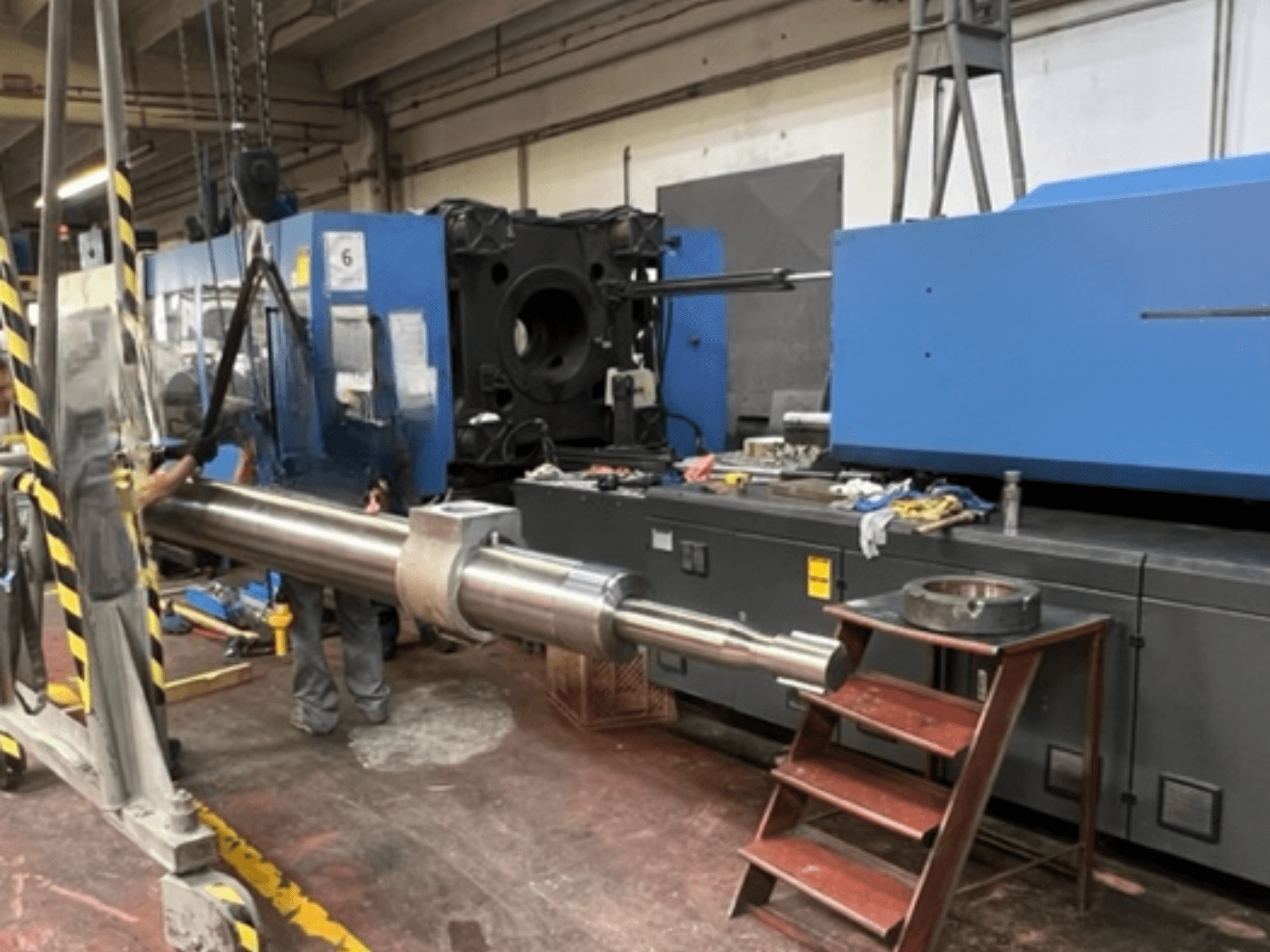 Presse à injection hydraulique HAITIAN SA8000, vue de profil montrant une grande tige hydraulique en cours de levage.