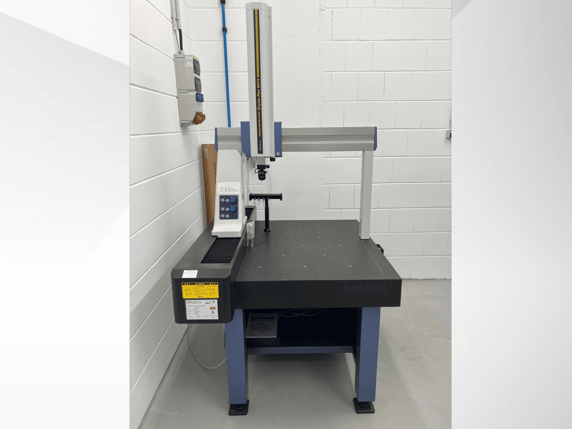 Machine de mesure par coordonnées Mitutoyo Crysta-Plus M574, vue de face ; elle est équipée d'un pont de mesure horizontal et d'un panneau de commande.