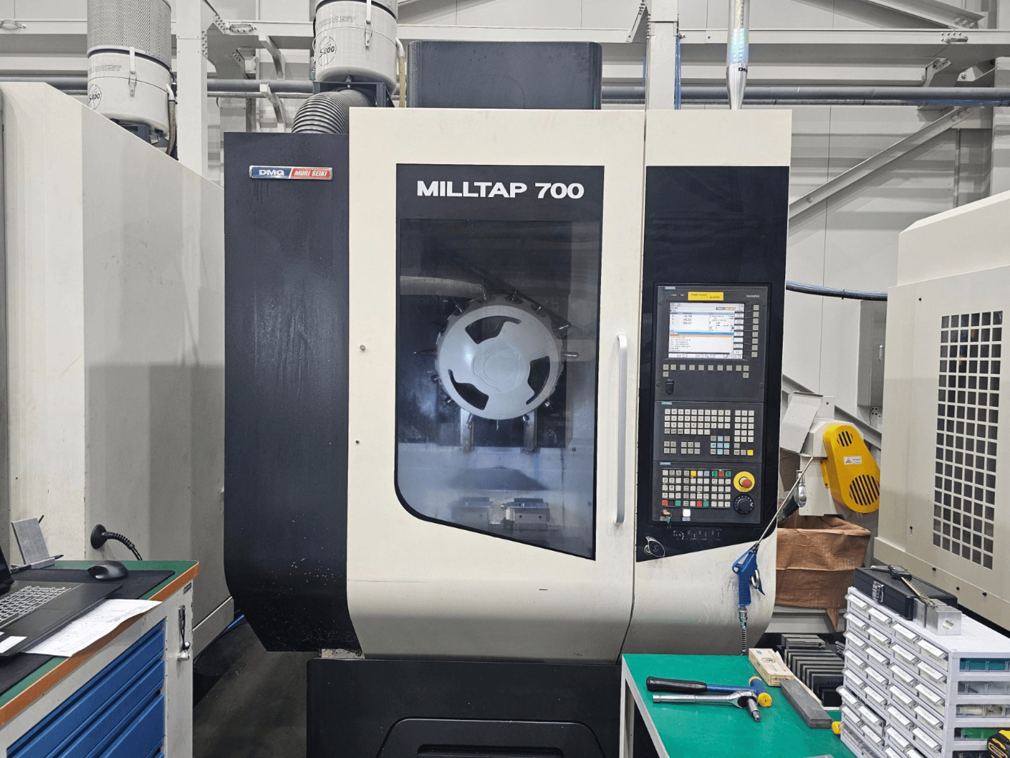 Centre d'usinage vertical DMG MORI MILLTAP 700, vue de face, présentant le panneau de commande, la broche et les détails de l'espace de travail.